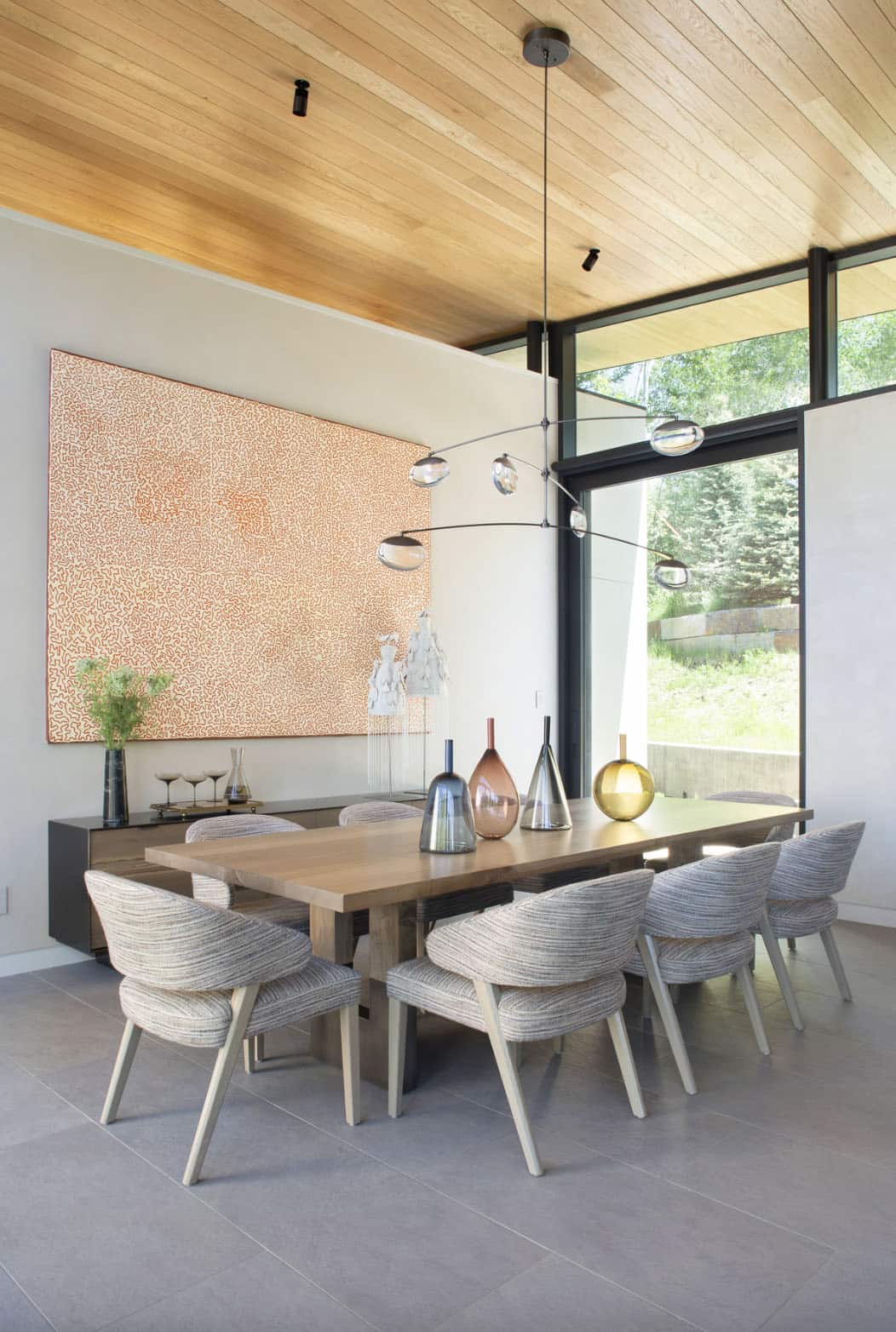 modern dining room with large artwork and a chandelier