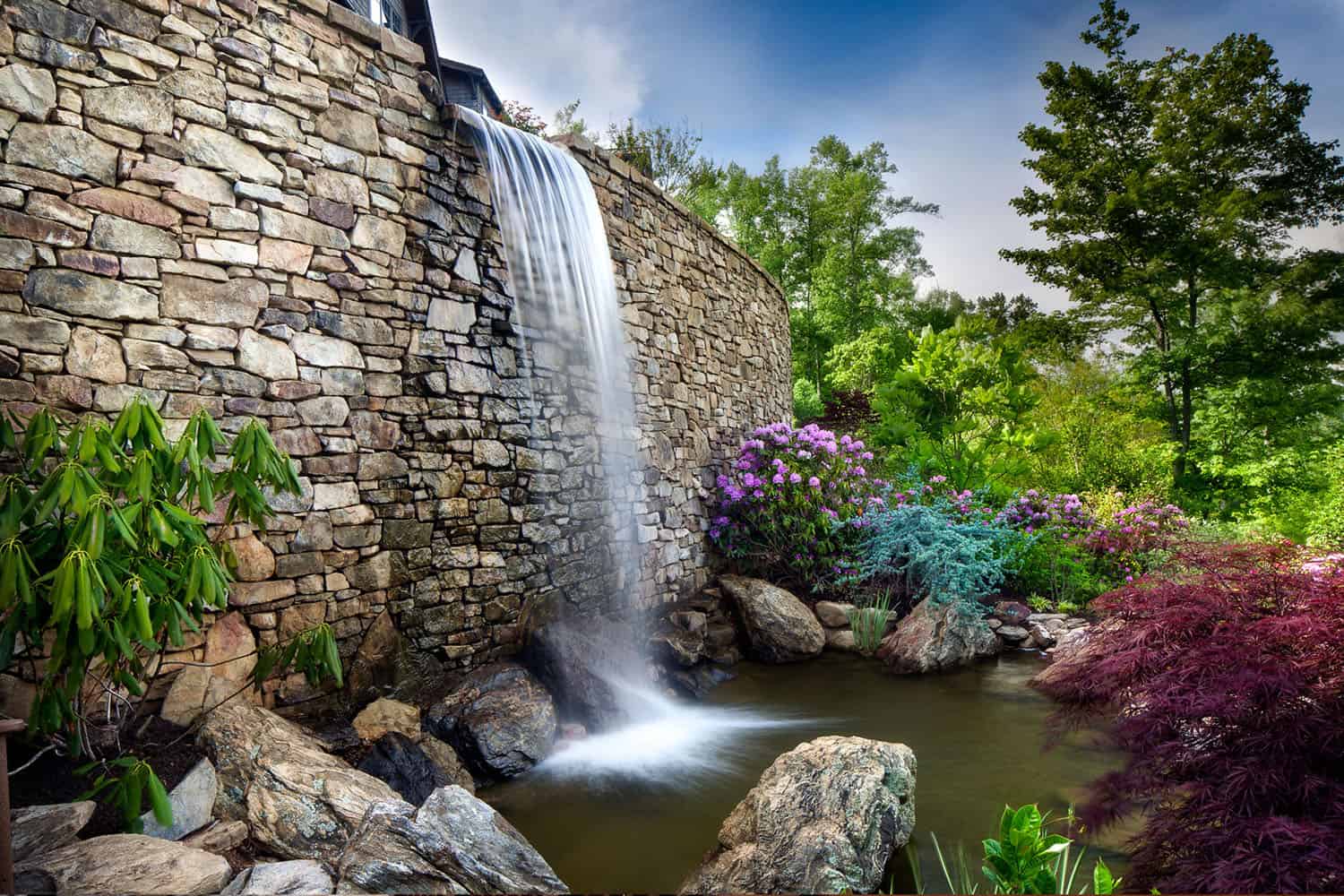 modern rustic mountain home exterior with a waterfall