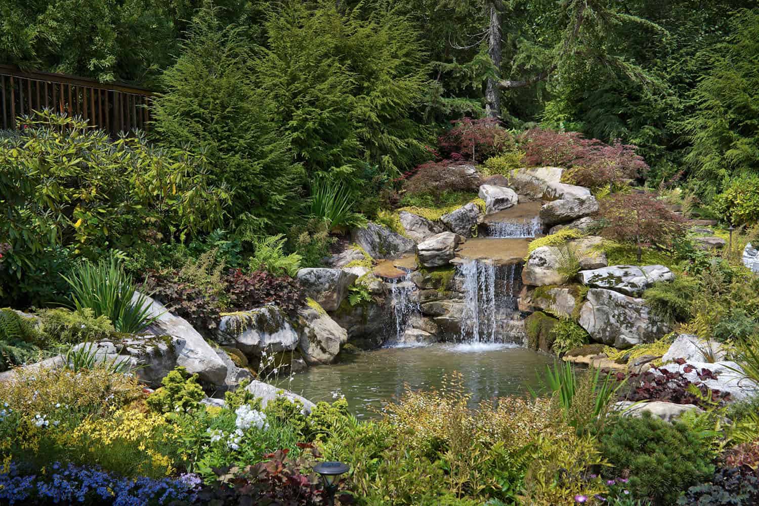 modern rustic mountain home exterior with a waterfall