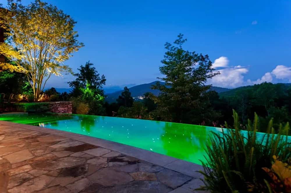 modern rustic mountain exterior with a pool at dusk