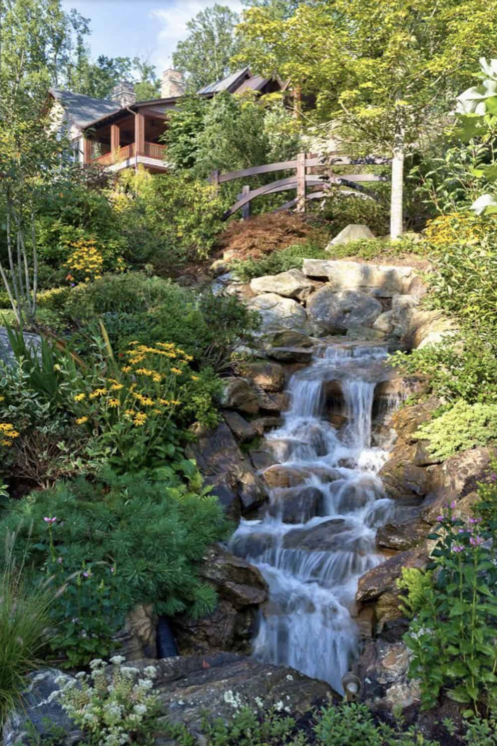 modern rustic mountain home exterior with a waterfall