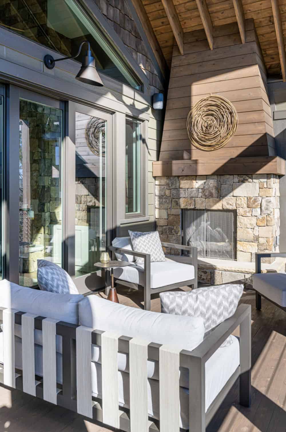 modern rustic mountain home exterior with a covered porch with outdoor furniture