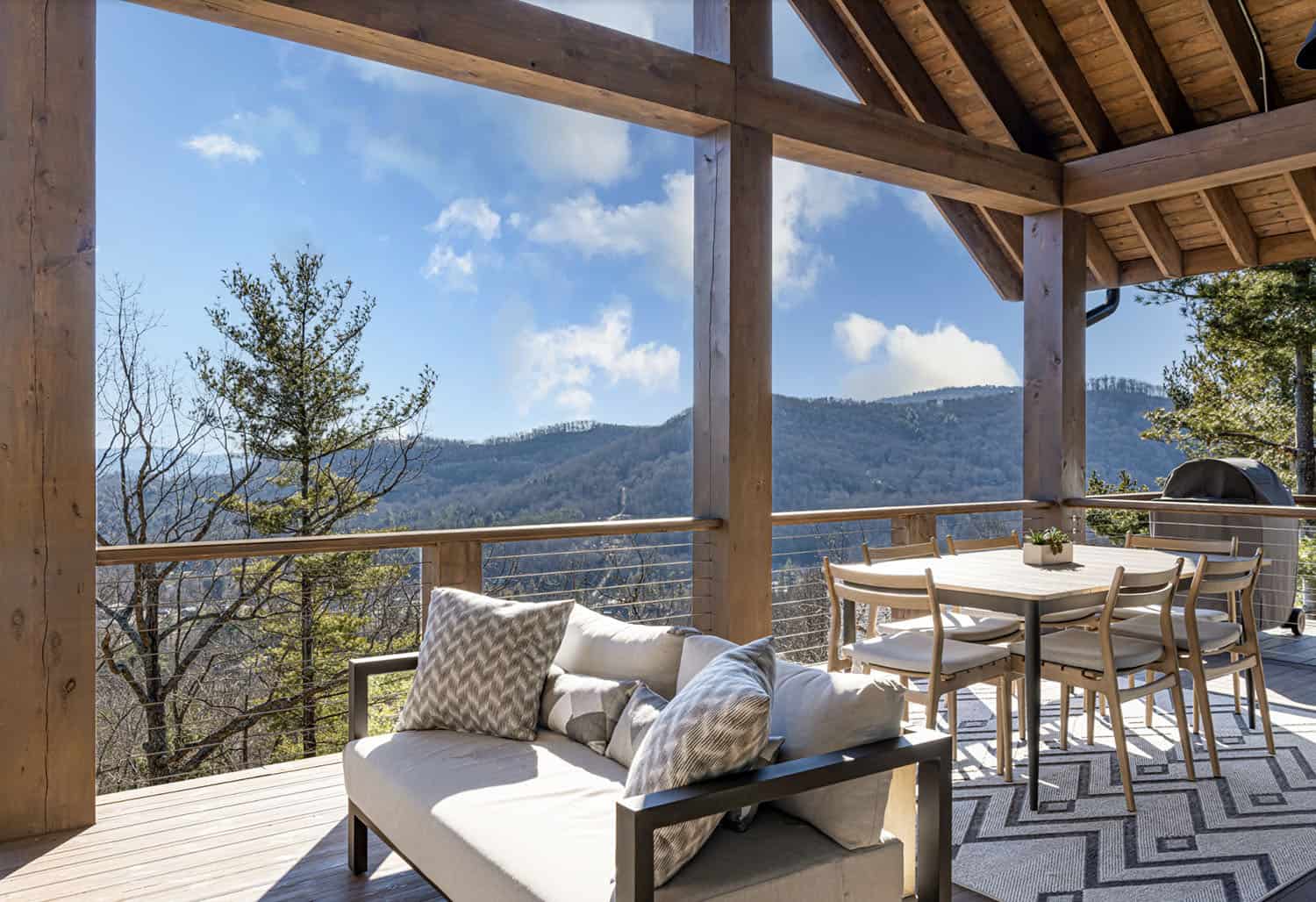 modern rustic mountain home exterior with a covered porch with outdoor furniture
