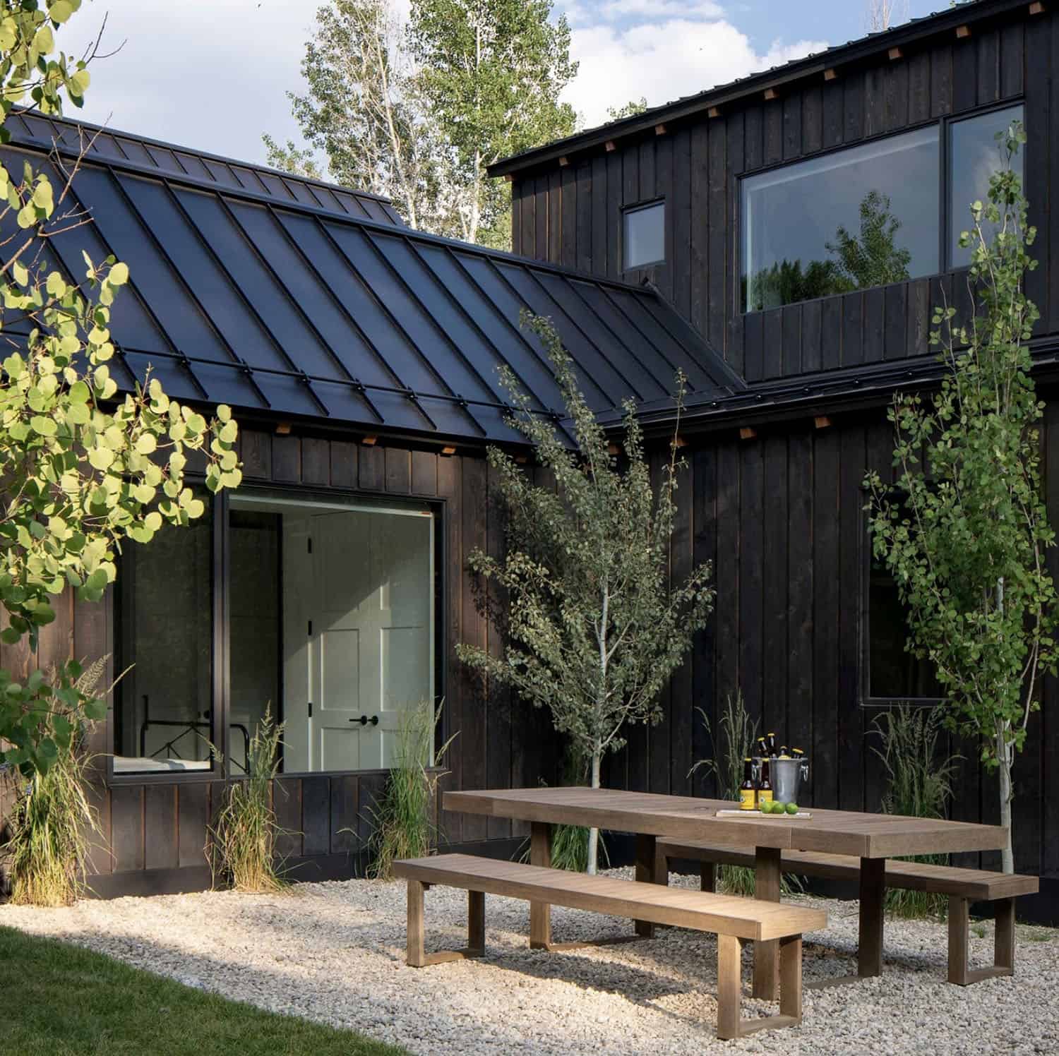 modern mountain home exterior backyard view with alfresco dining