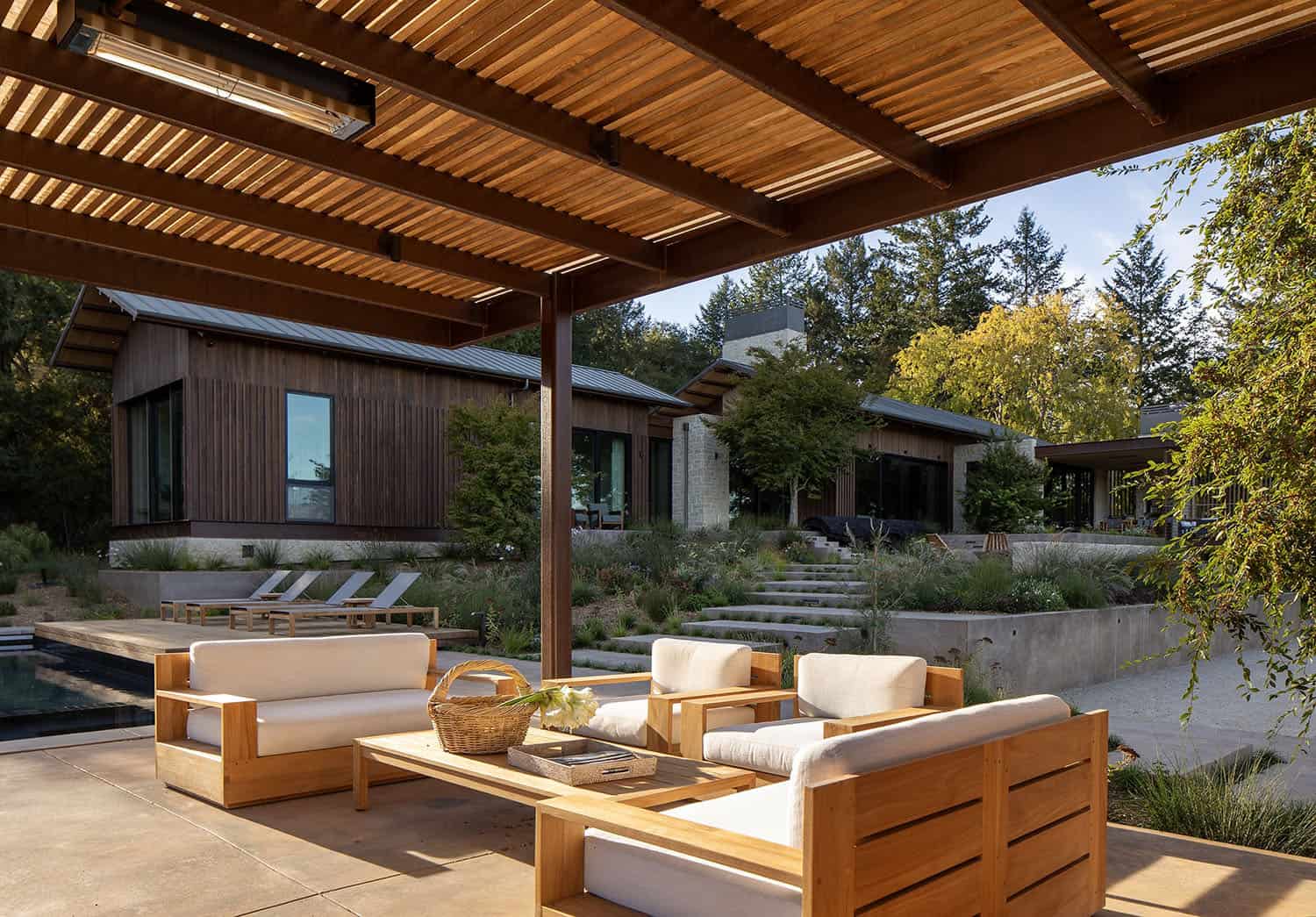 modern farmhouse exterior with a pergola and outdoor furniture