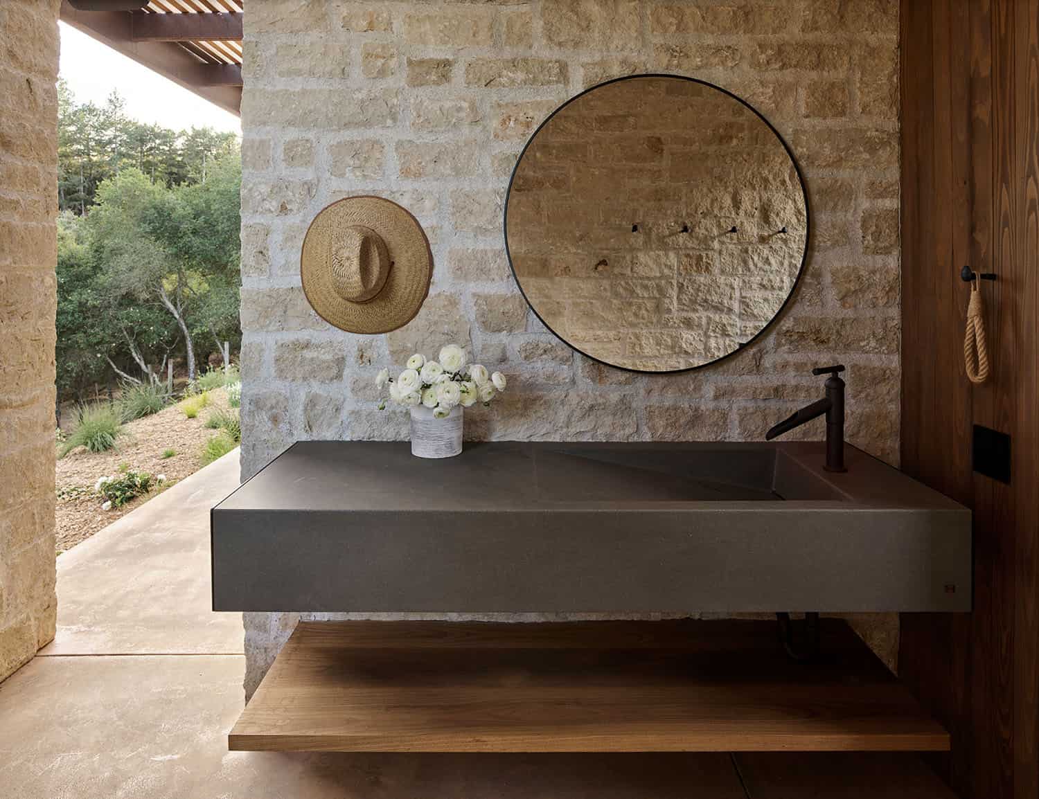 modern farmhouse pool house bathroom with a vanity and round mirror