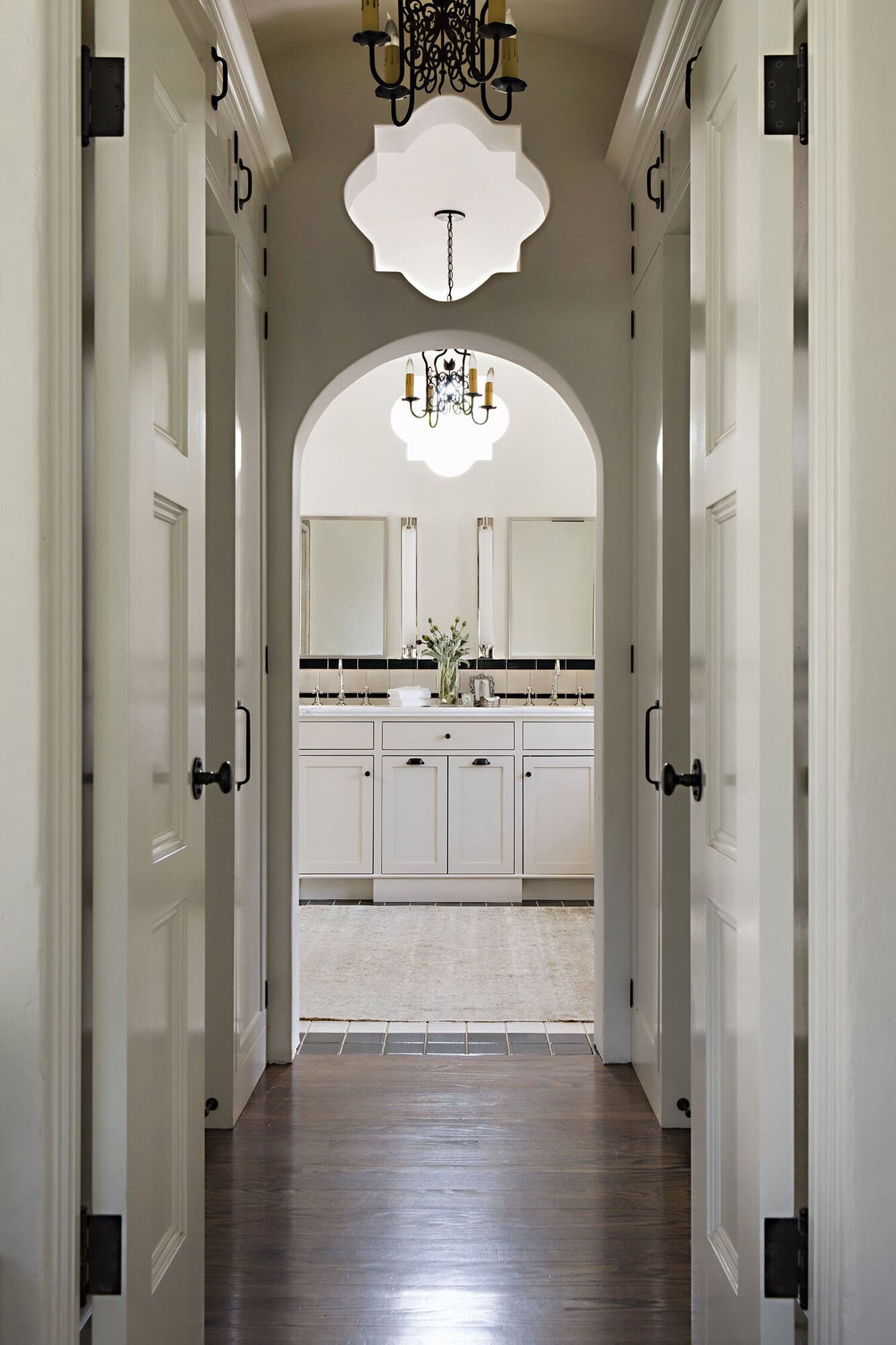 spanish colonial revival hallway with an arched entry into the bathroom
