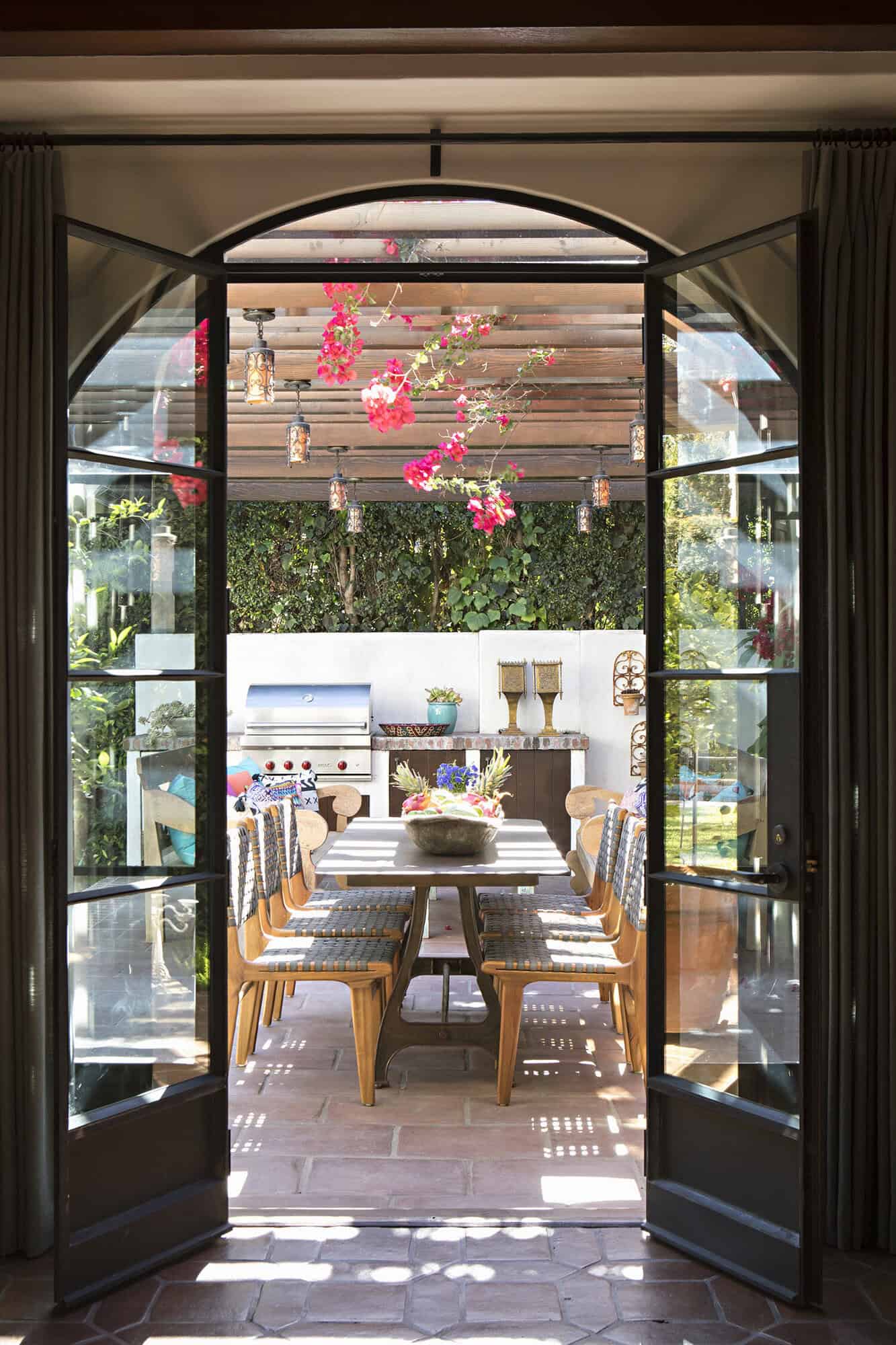 spanish colonial revival glass doors leading out to the backyard patio