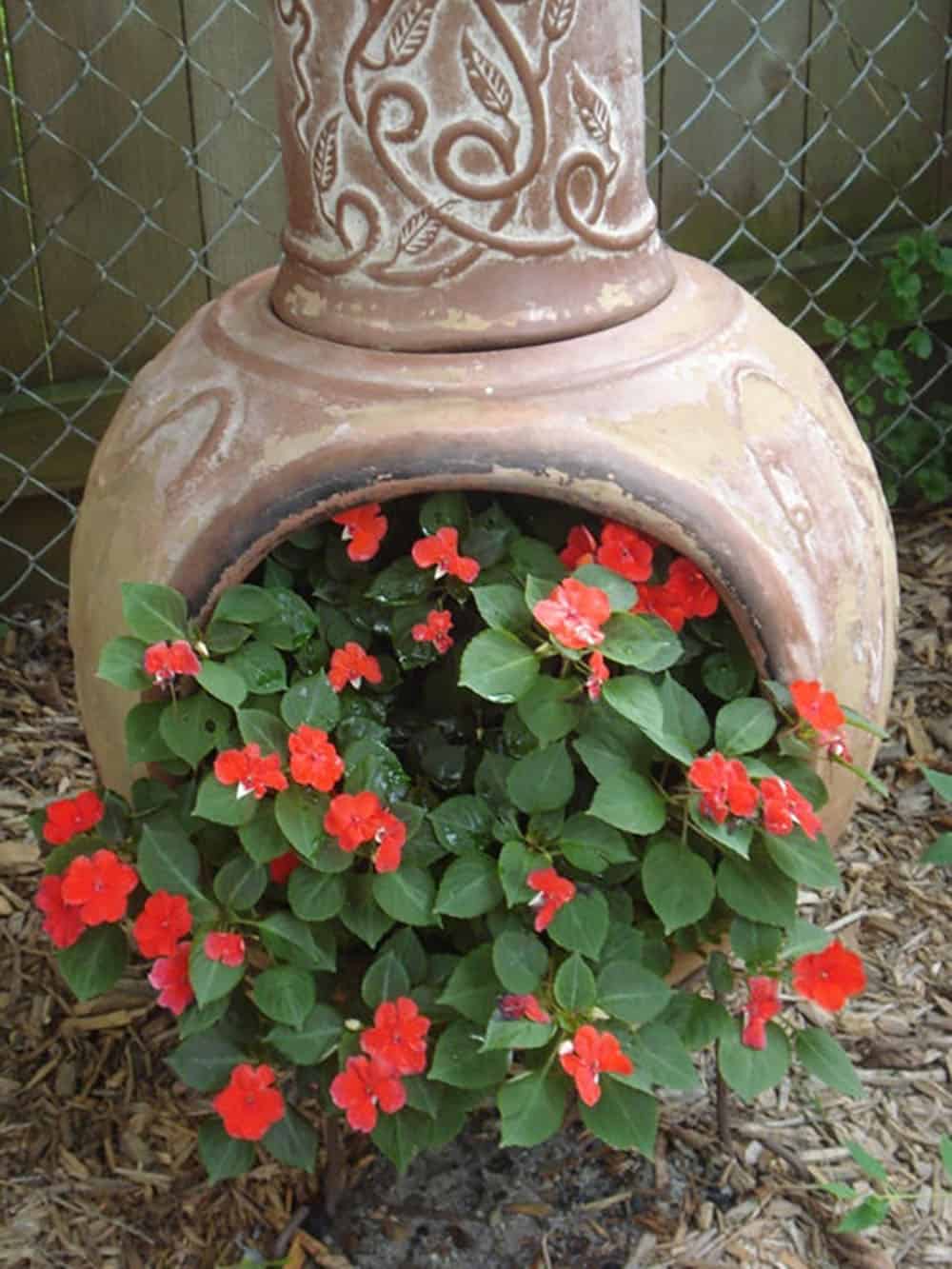 cracked chimnea with spilled flowers