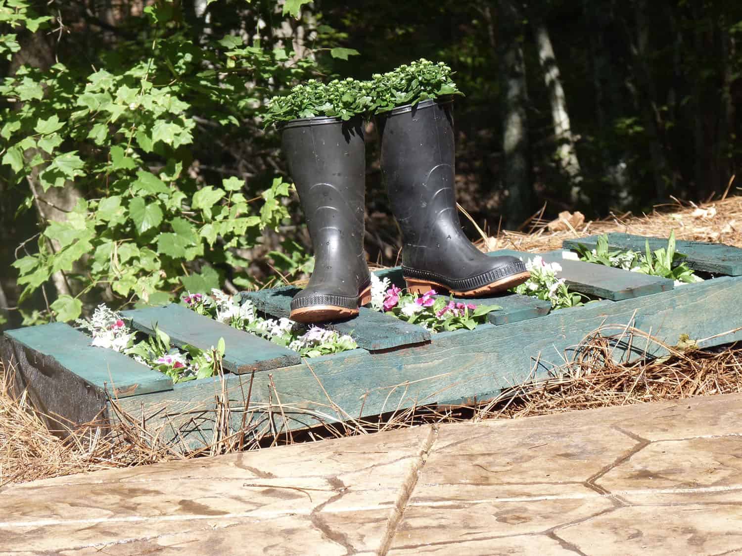 upcycle wood pallet with boots filled with spilled flowers