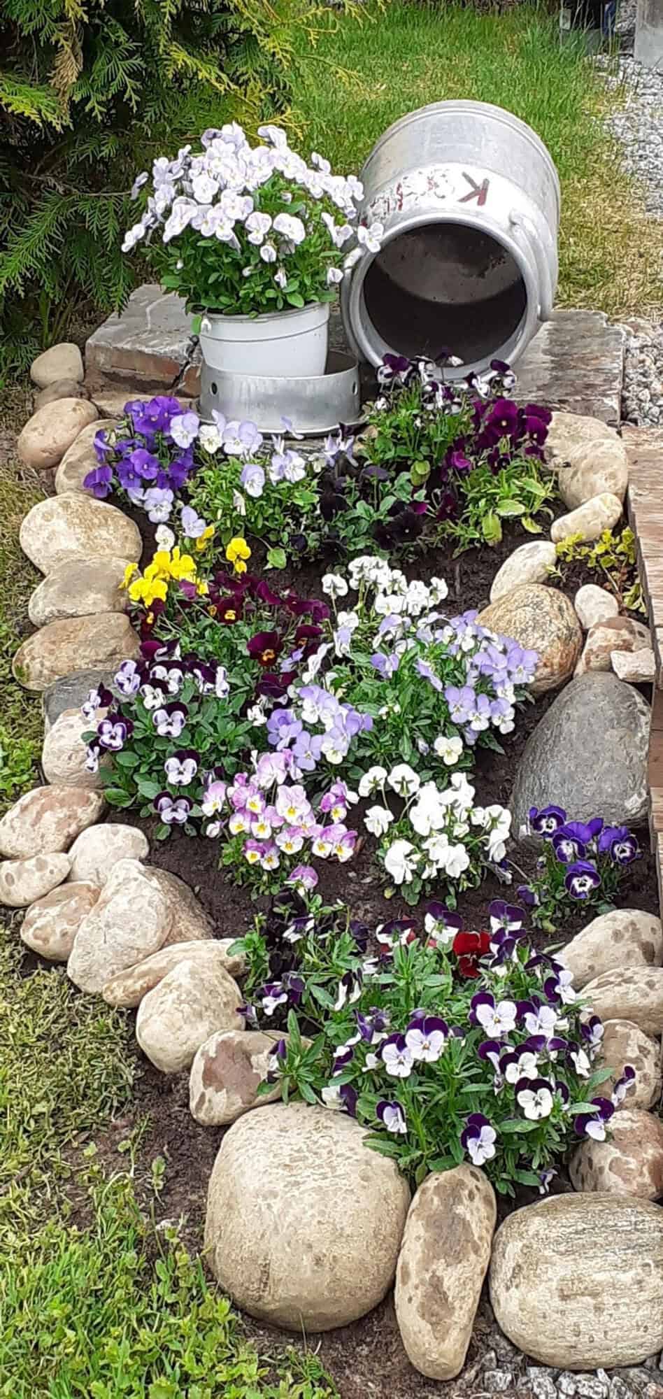 flower bed defined by stone with a spilled pot