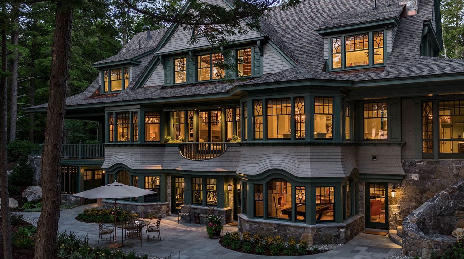 traditional style lake house exterior backyard view at dusk