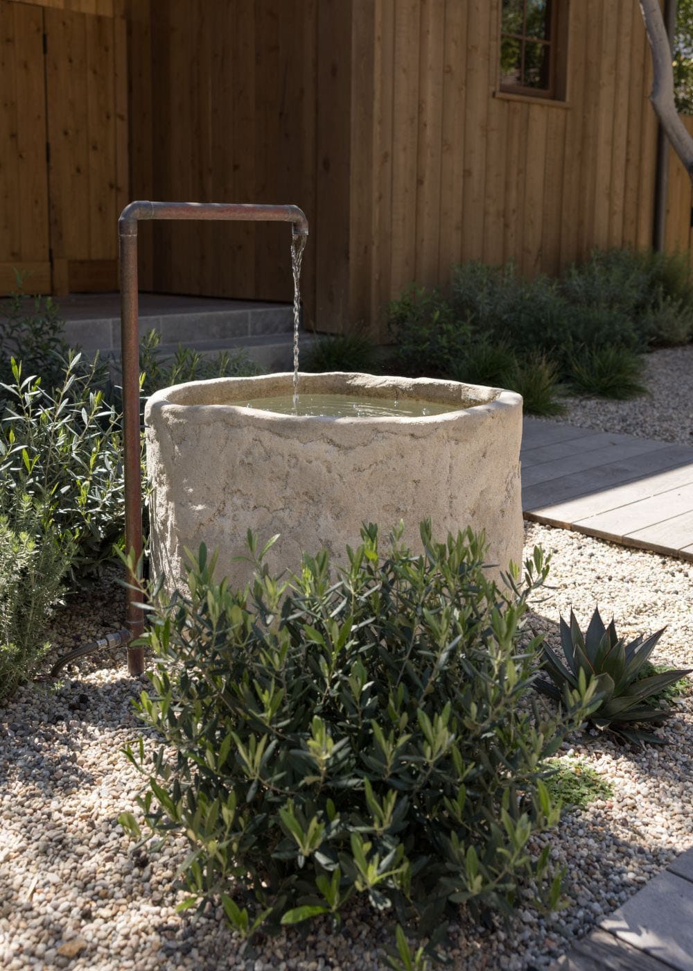 farmhouse style home exterior landscape with a water feature