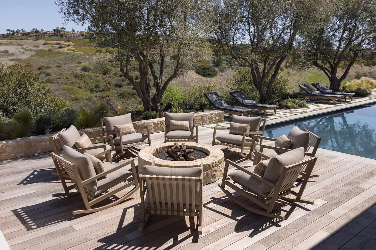 farmhouse style home exterior patio with a fire pit and lounge chairs