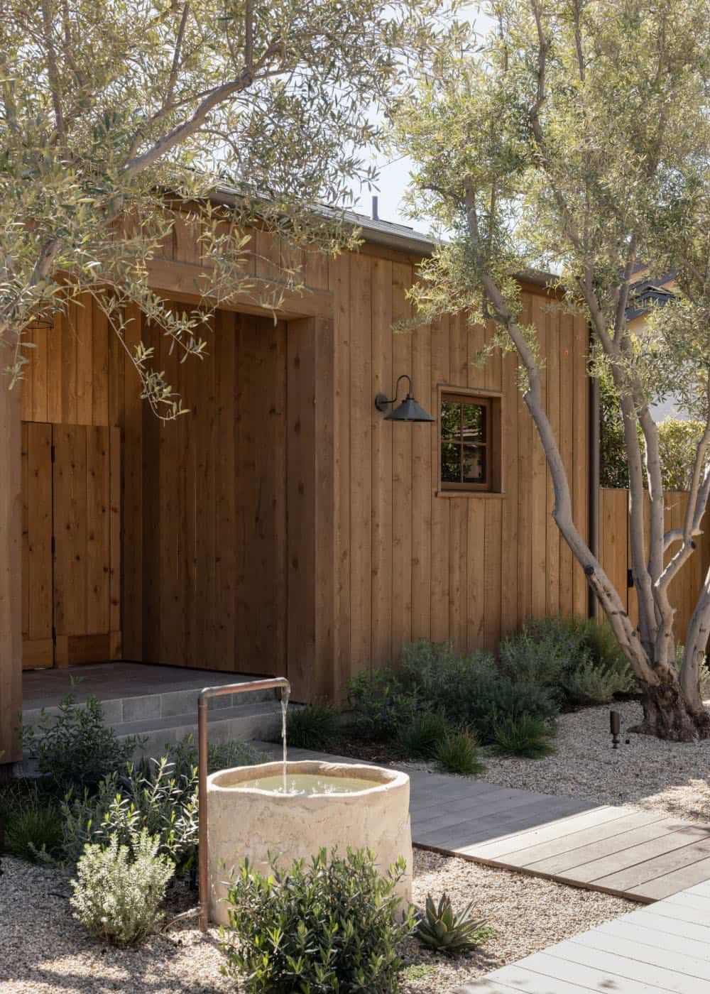 farmhouse style home exterior landscape with a water feature