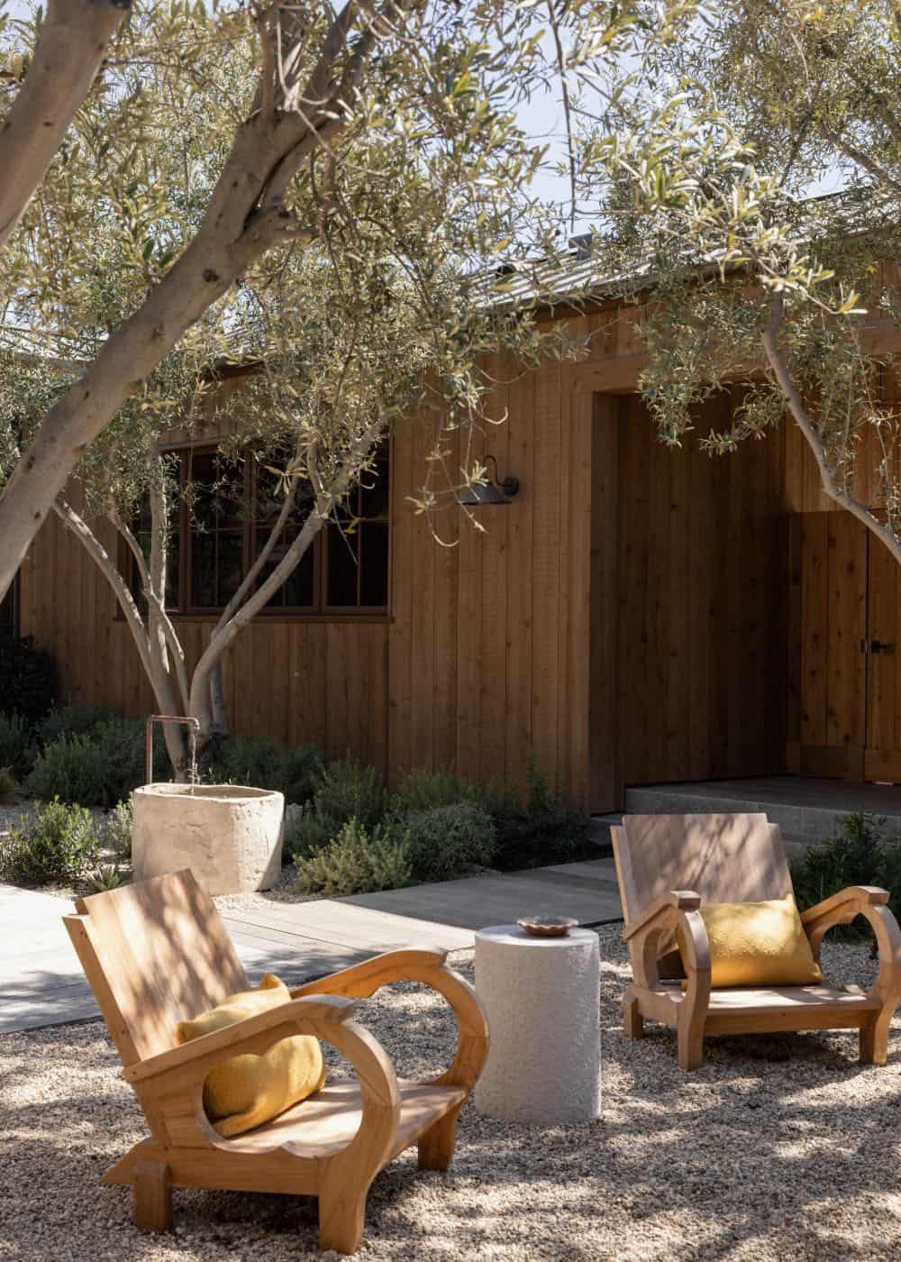 farmhouse style home exterior patio with a fire pit and lounge chairs