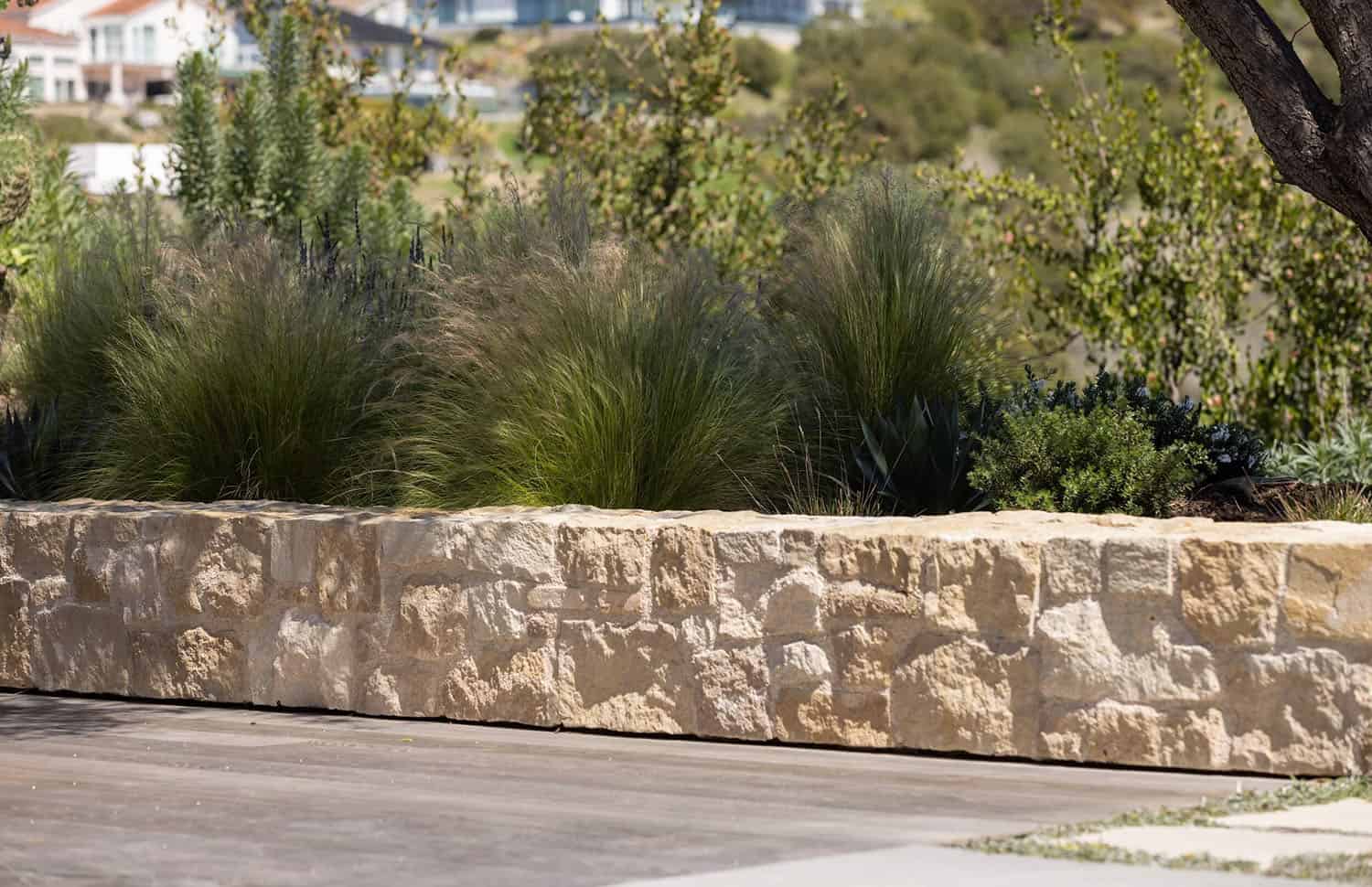 farmhouse style home landscape with a retaining wall