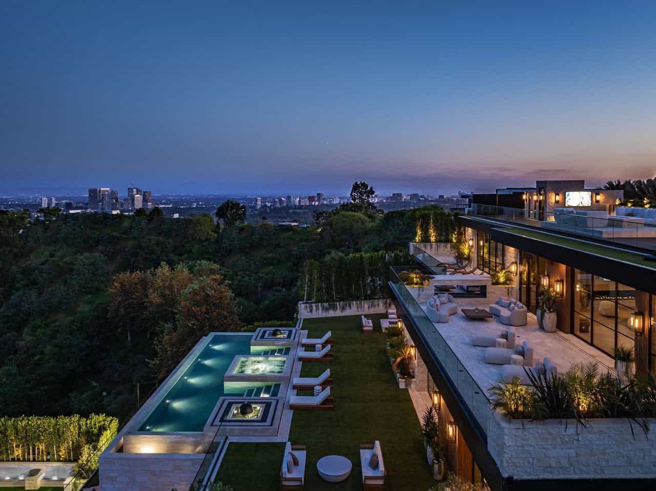 hillside home exterior with a pool at dusk