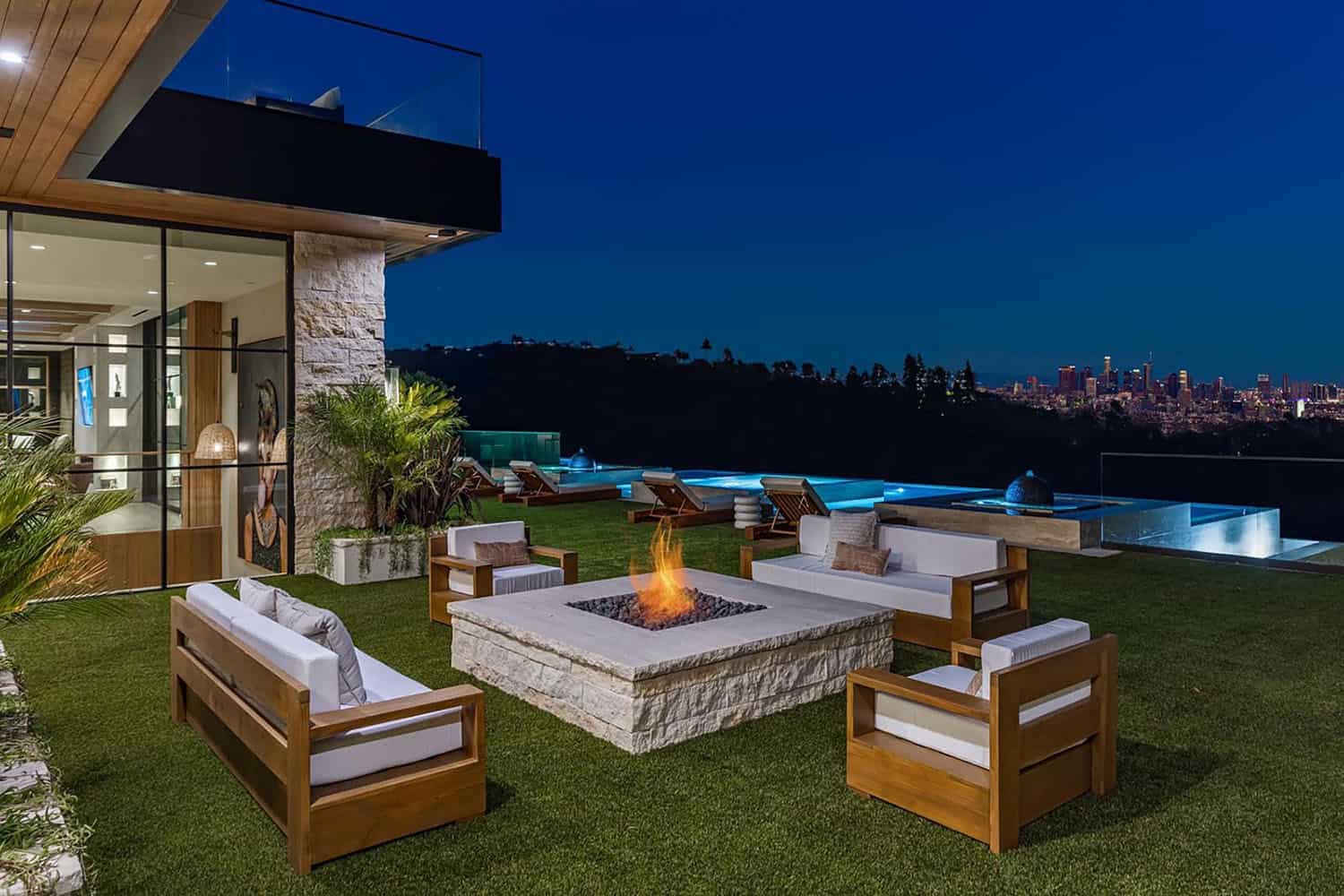 hillside home patio with a fire pit and outdoor furniture