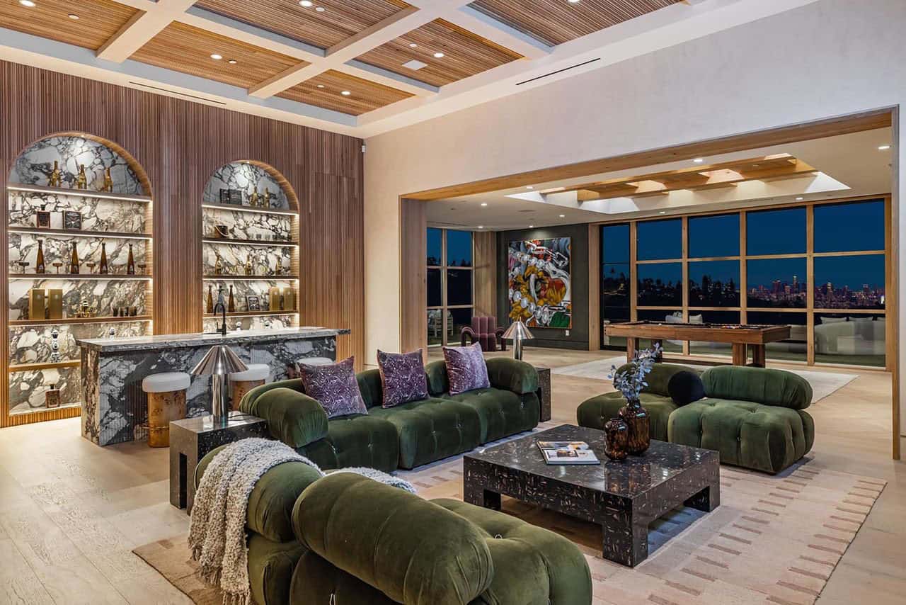 modern lower-level family room with a home bar at dusk