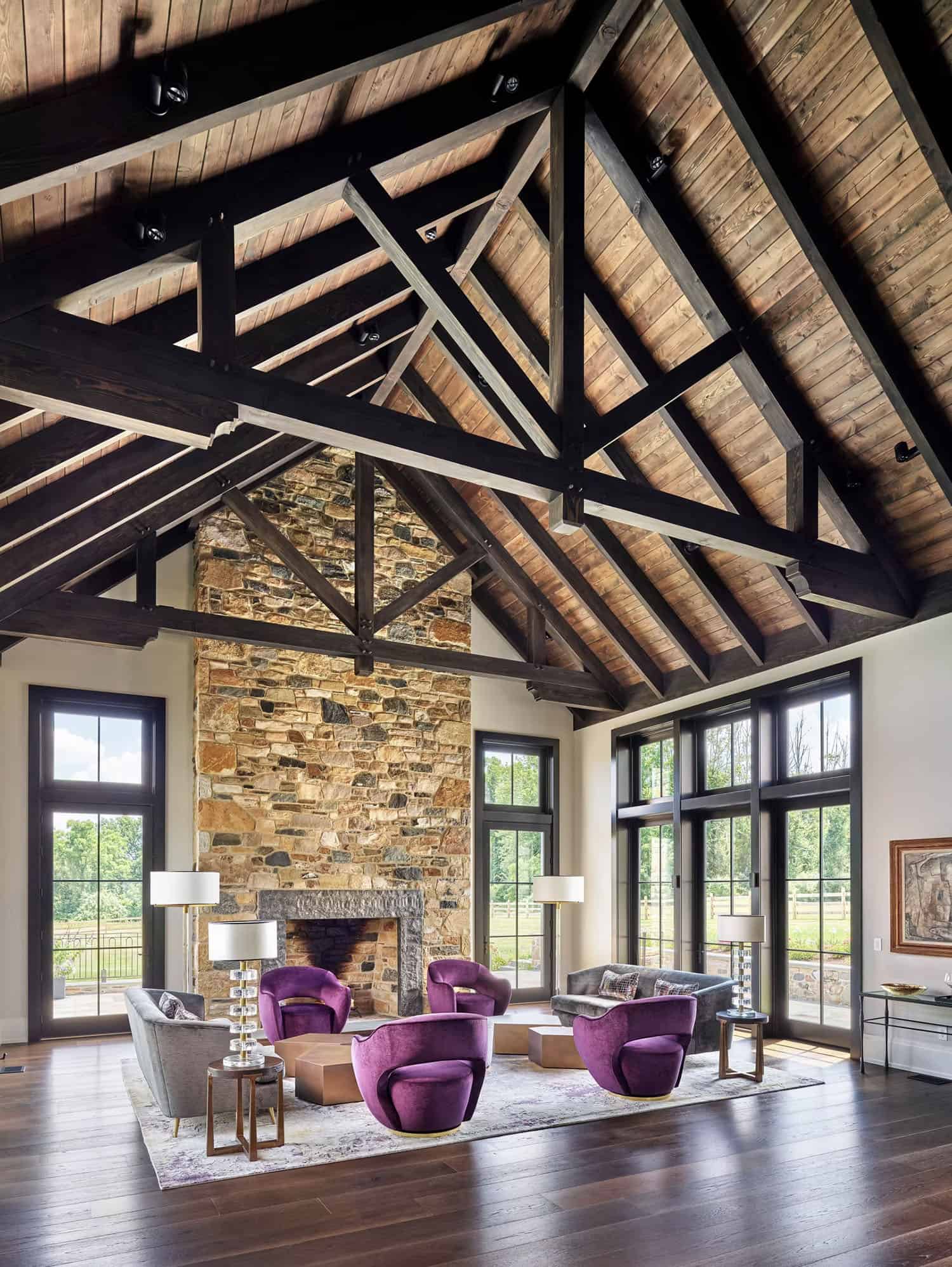 contemporary farmhouse style living room with a stone fireplace and two-story ceiling