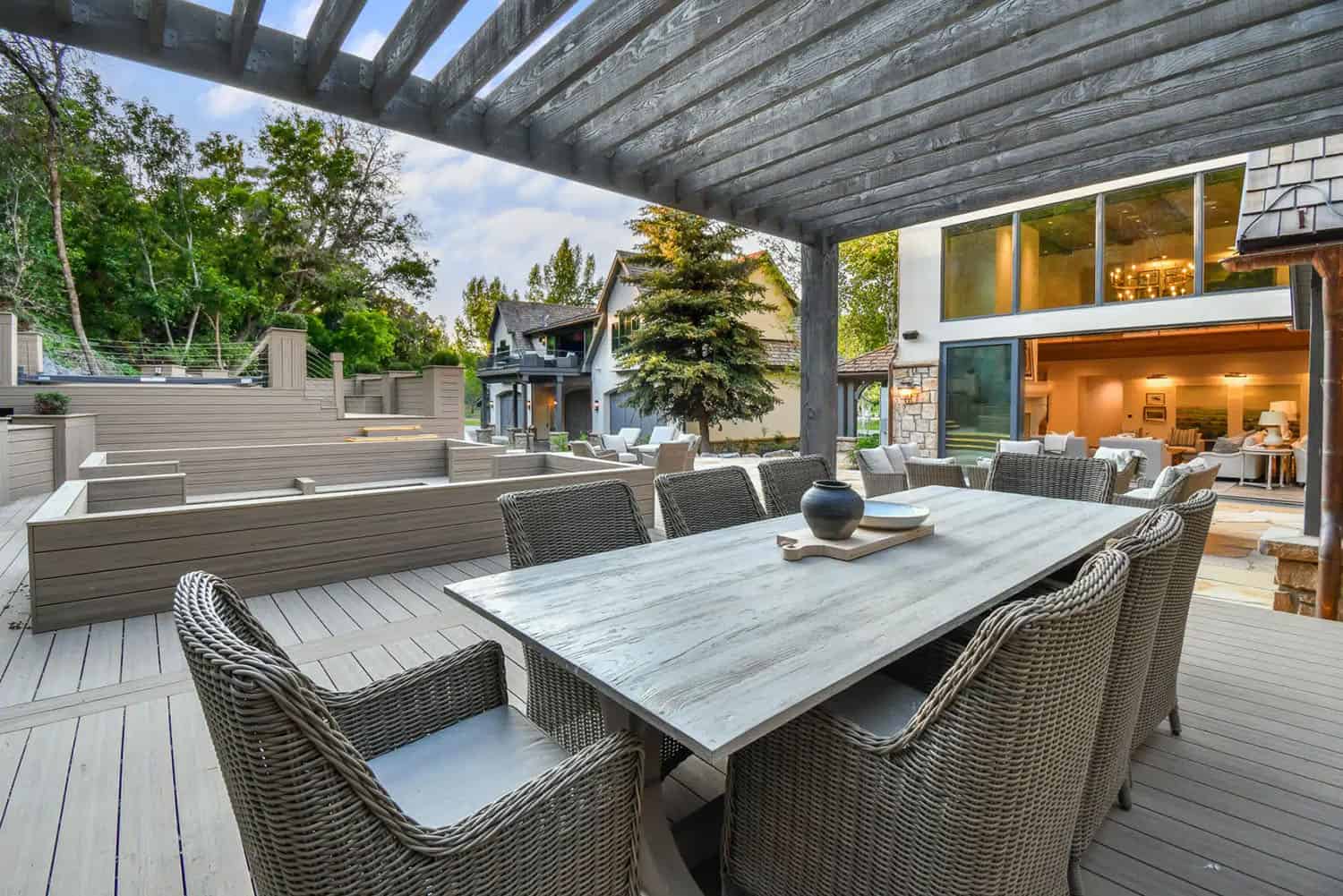 contemporary french country home patio with a pergola and dining furniture