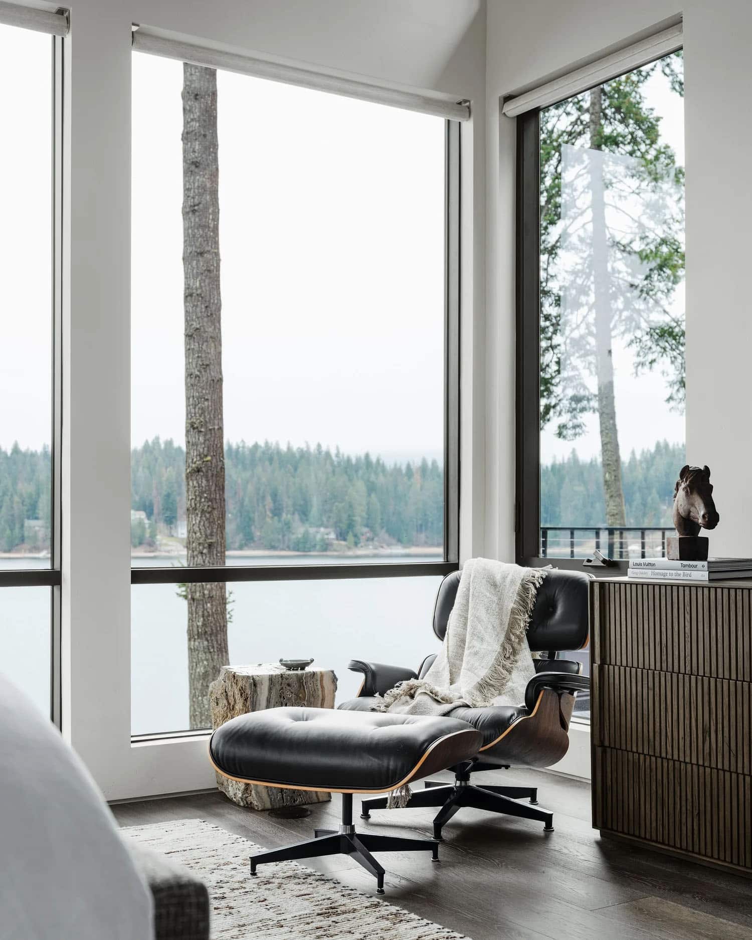 contemporary bedroom with an Eames chair and lake views