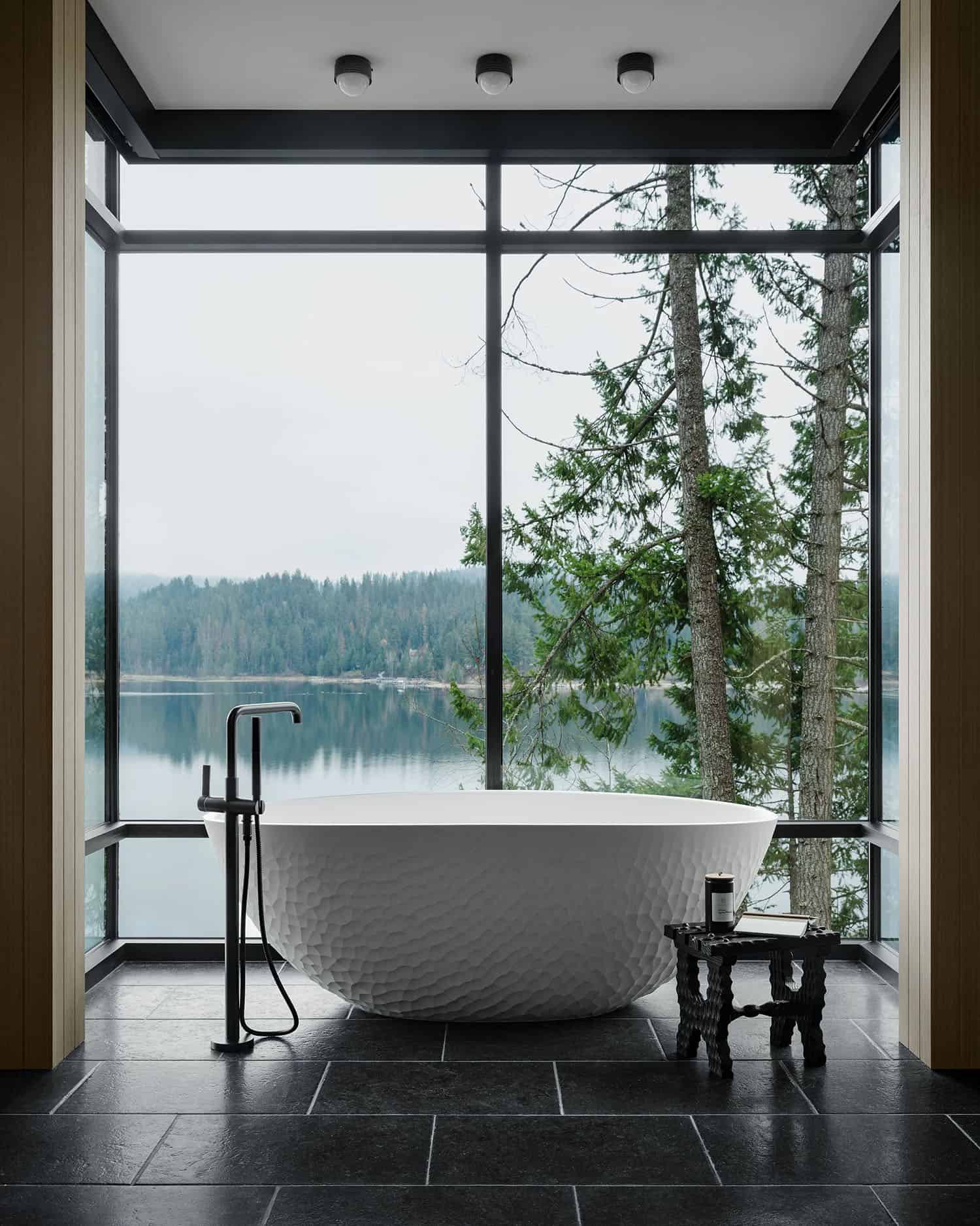 contemporary bathroom with a freestanding tub and lake views