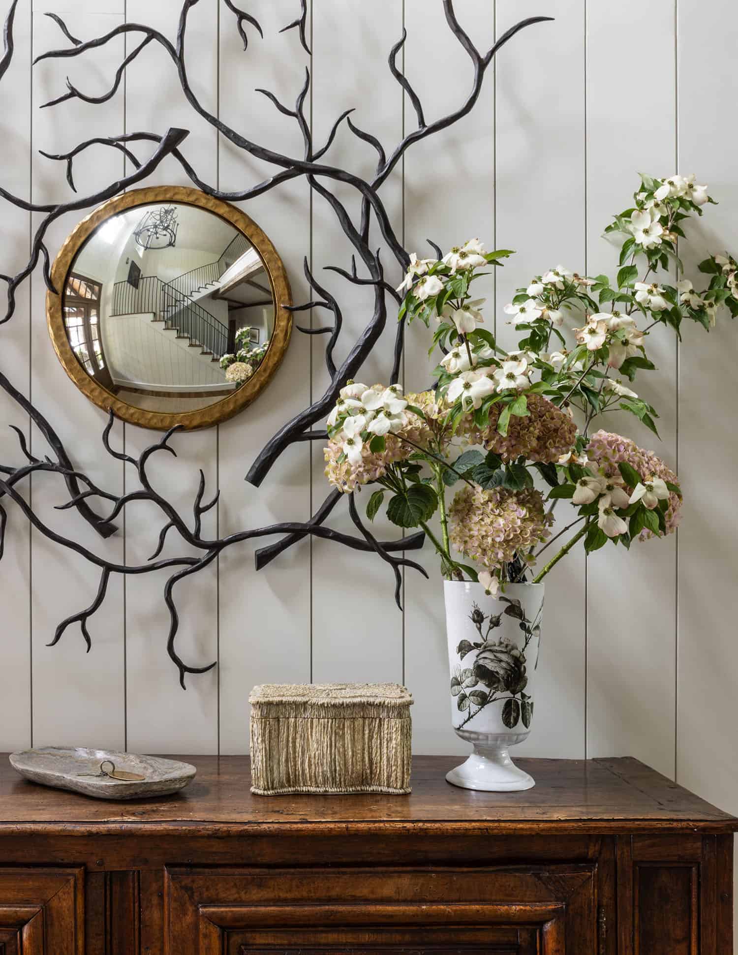 wood entry console with a vase and a mirror