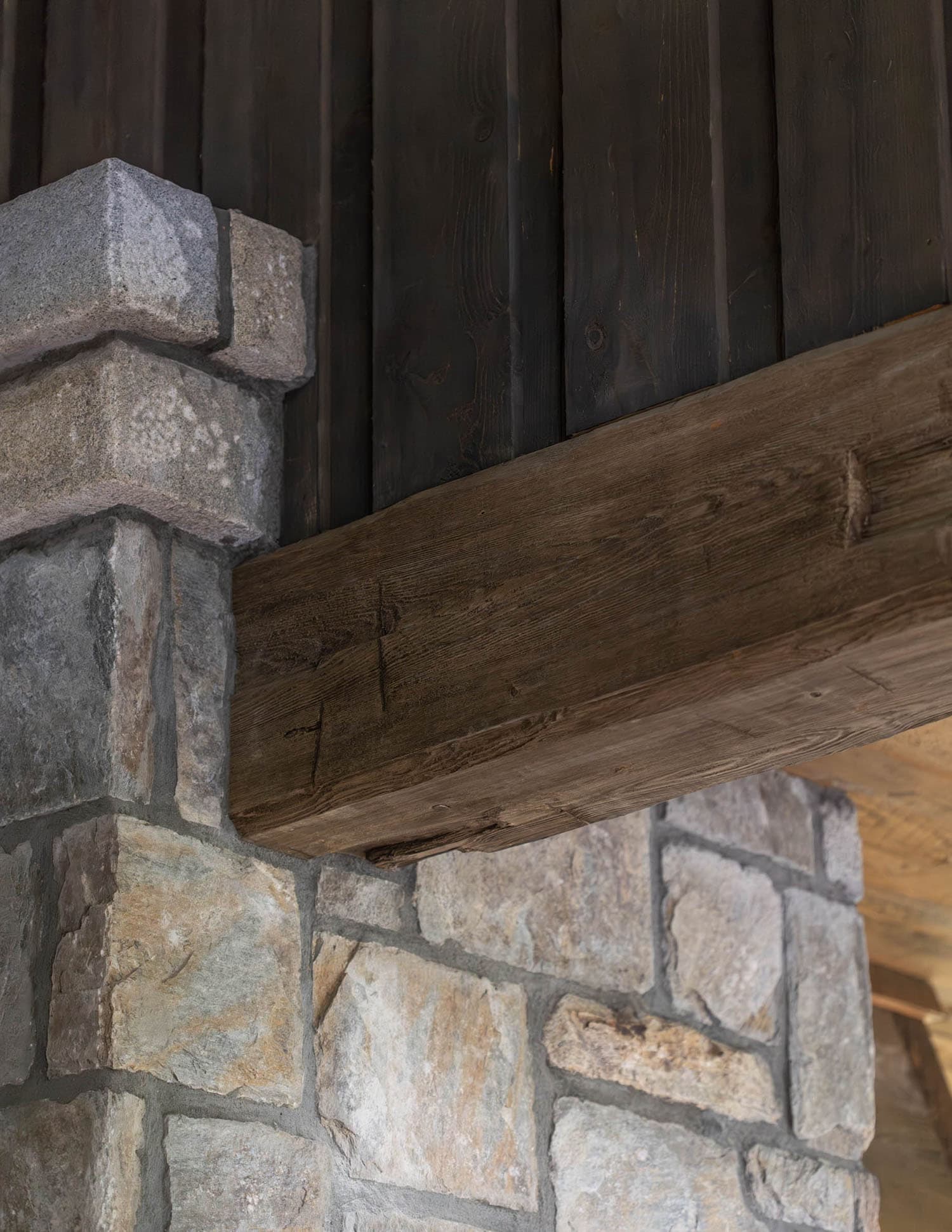 European-inspired covered porch stone wall and wood beam detail