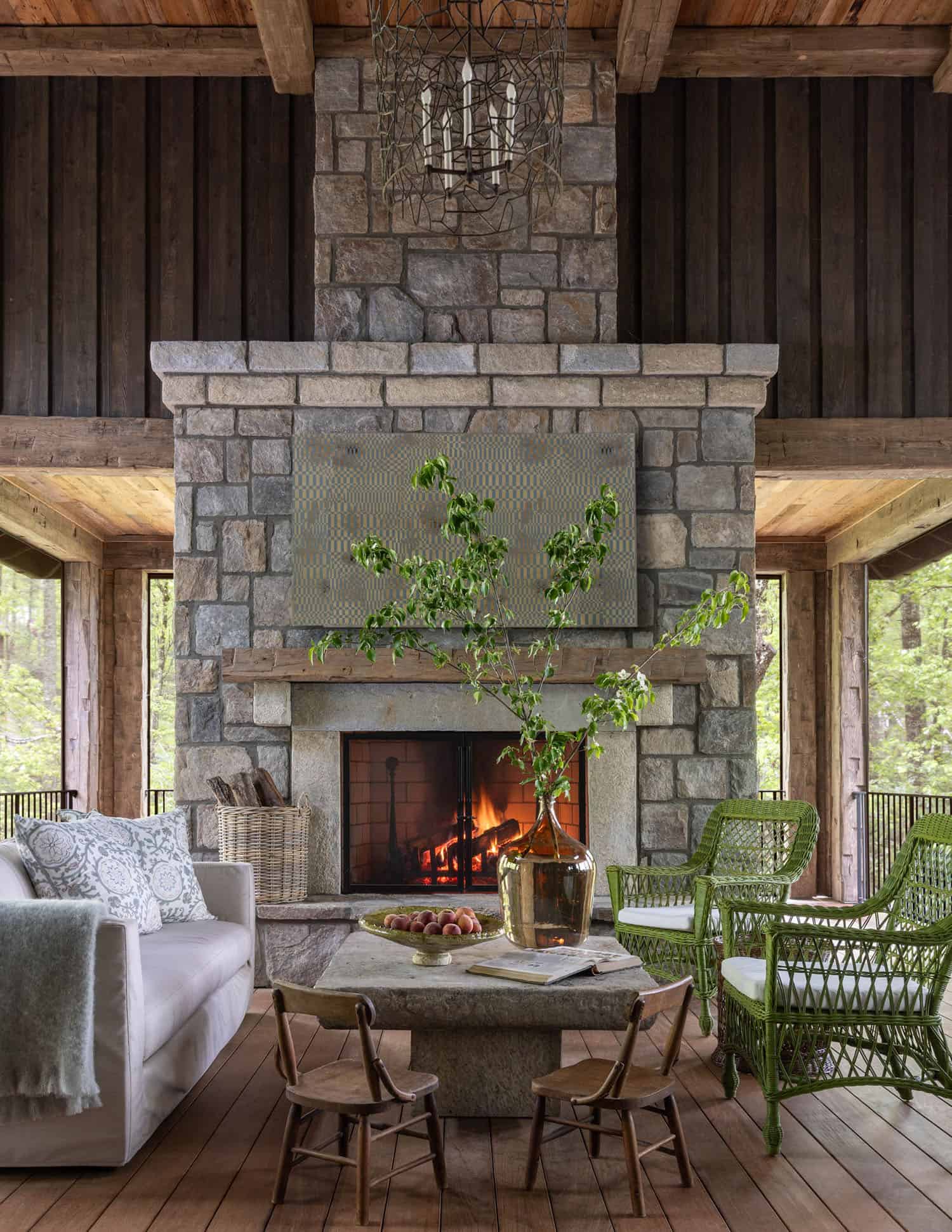 transitional style screened porch with a fireplace and furniture