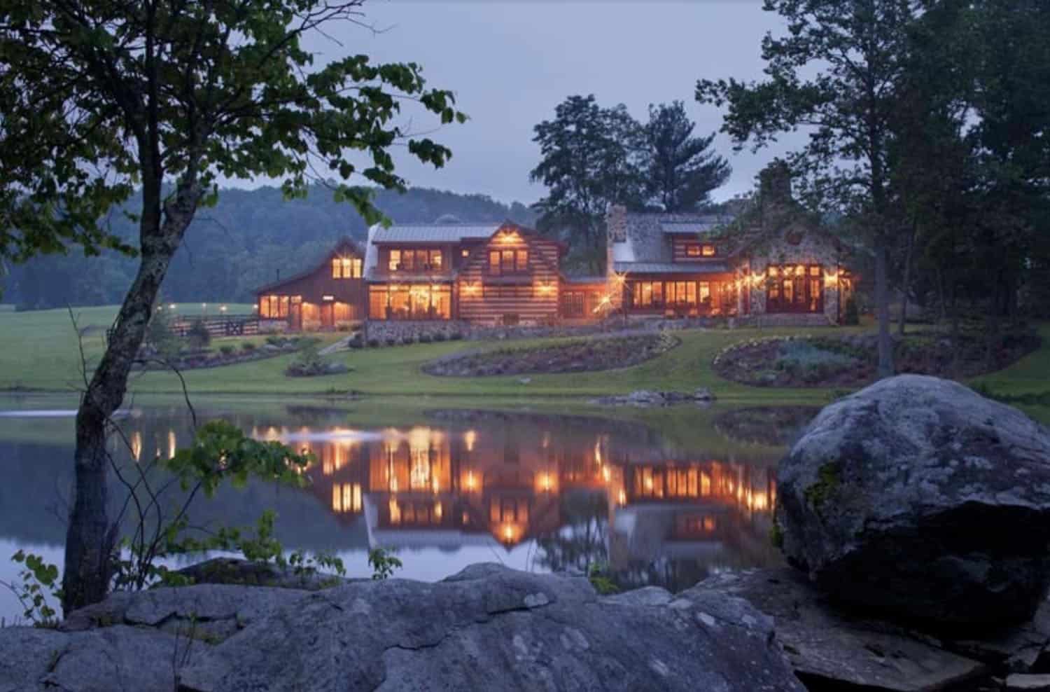rustic log and stone home exterior at dusk
