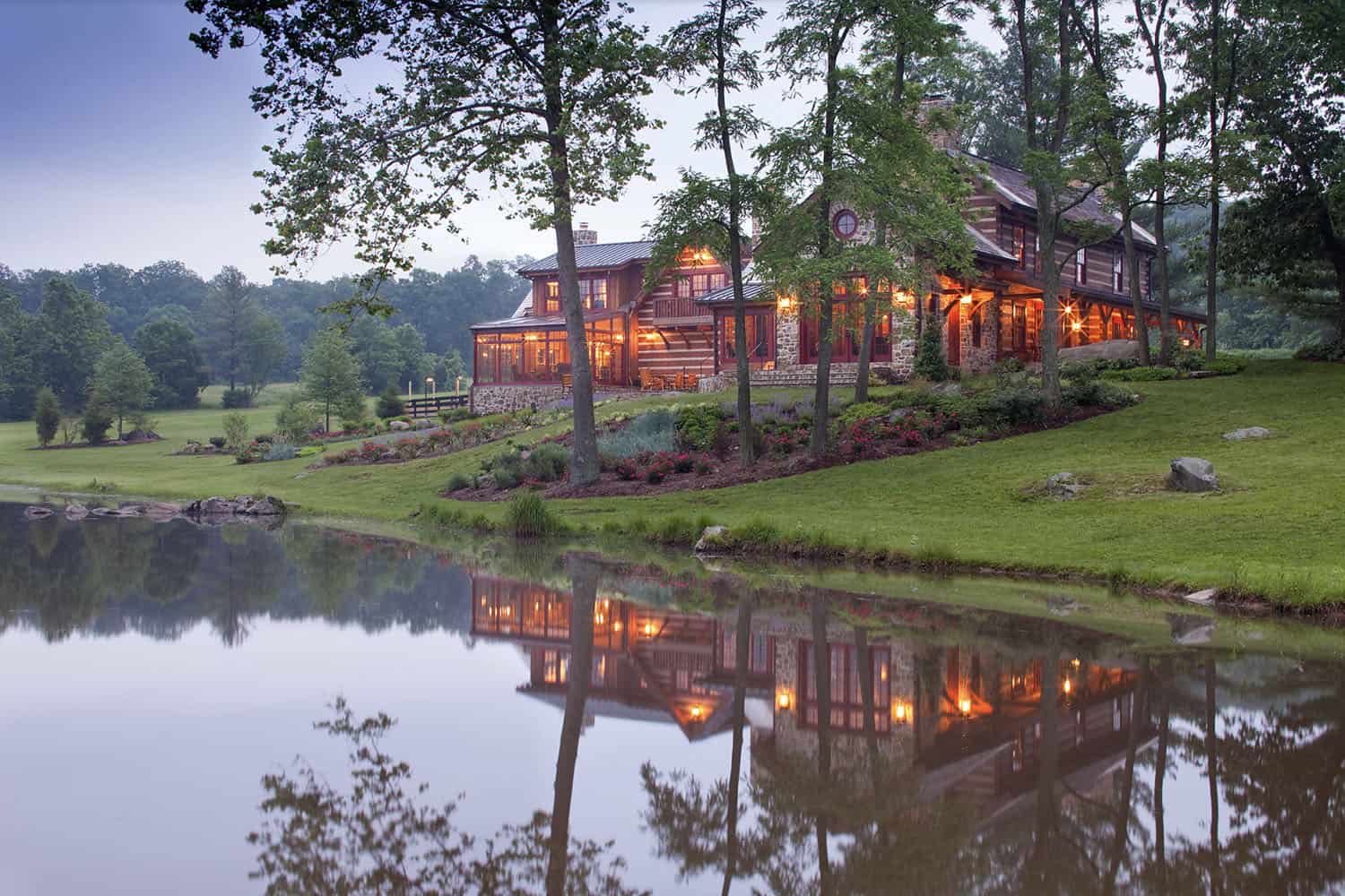 rustic log and stone home exterior at dusk
