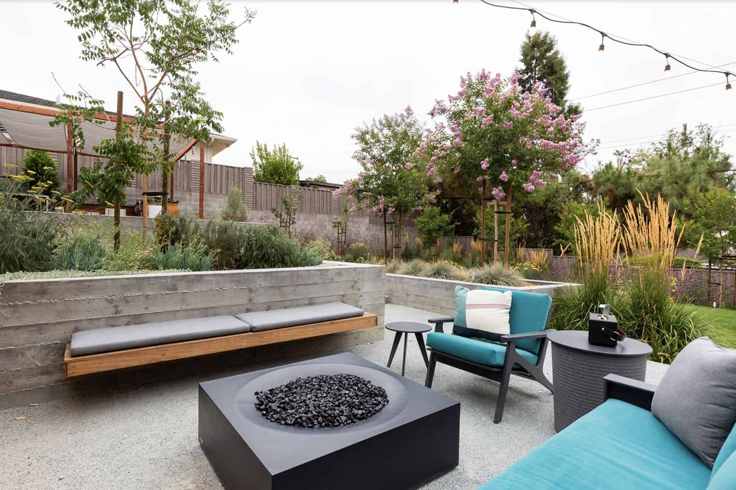 concrete patio with a modern planter box and a fire pit