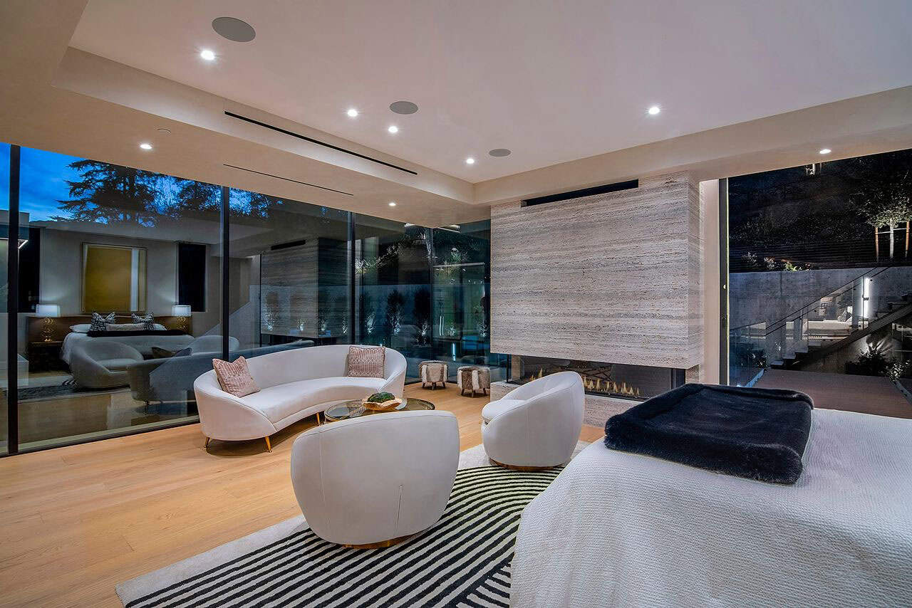 modern bedroom with a sitting area and fireplace