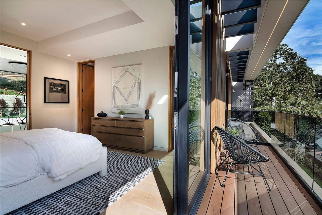 modern bedroom with sliding glass doors leading out to a private balcony