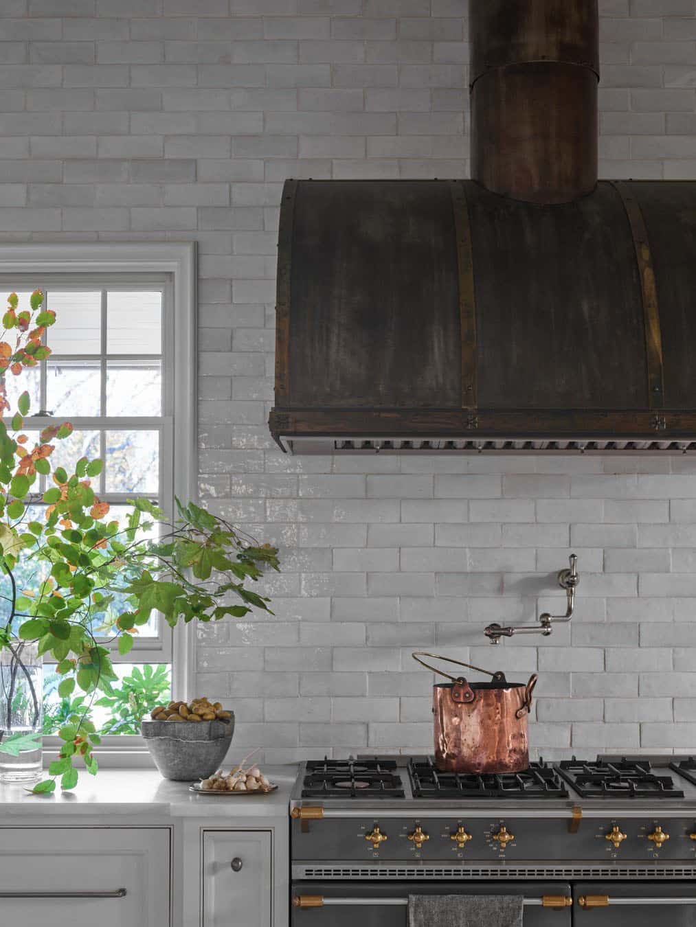 modern english tudor style kitchen with a custom metal hood