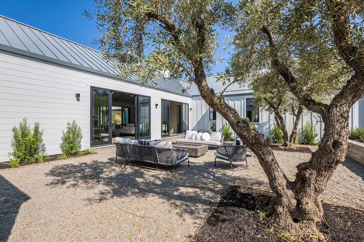 modern farmhouse style home exterior with a patio and outdoor furniture