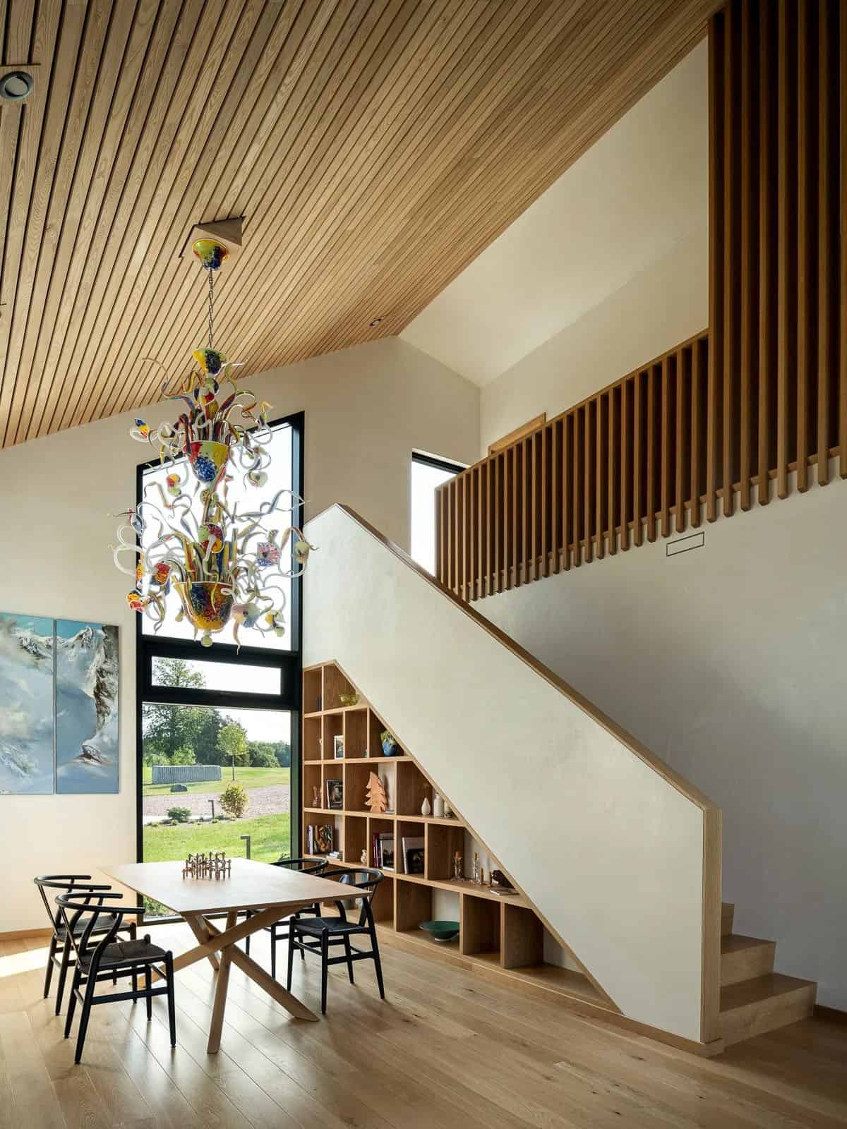 modern dining room with built-in bookshelves and a staircase