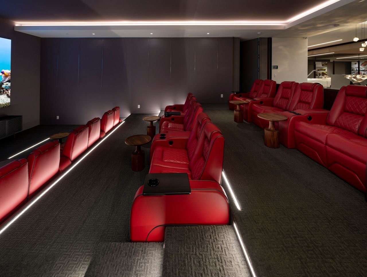 A home theater with red seats and a large screen.