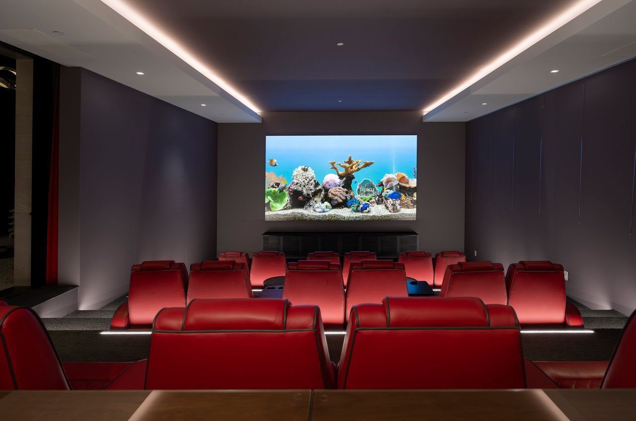 A home theater with red seats and a large screen.
