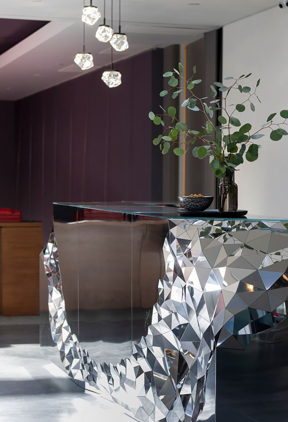 A modern reception desk with a large mirror.