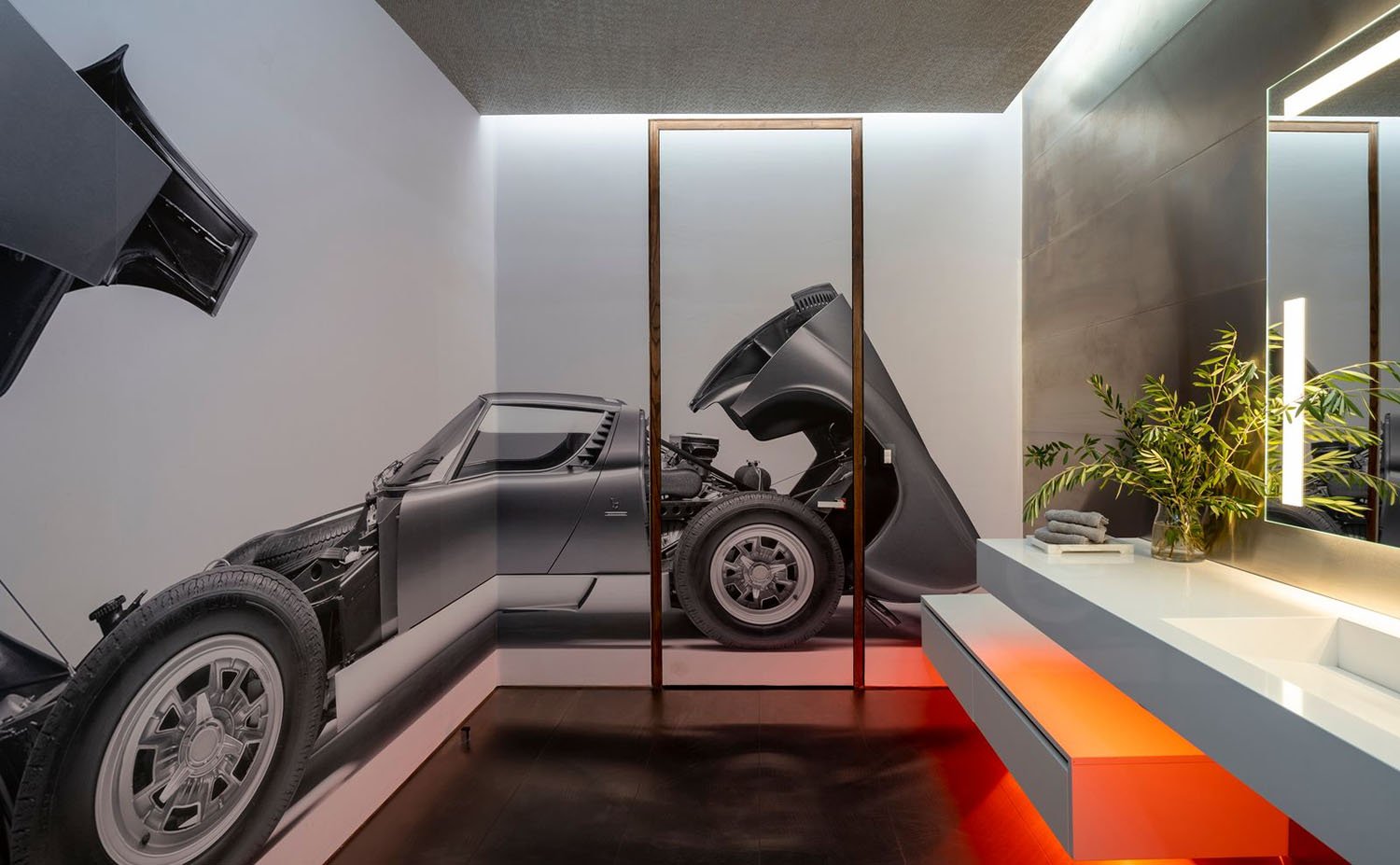 A bathroom with a car on the wall and a sink.