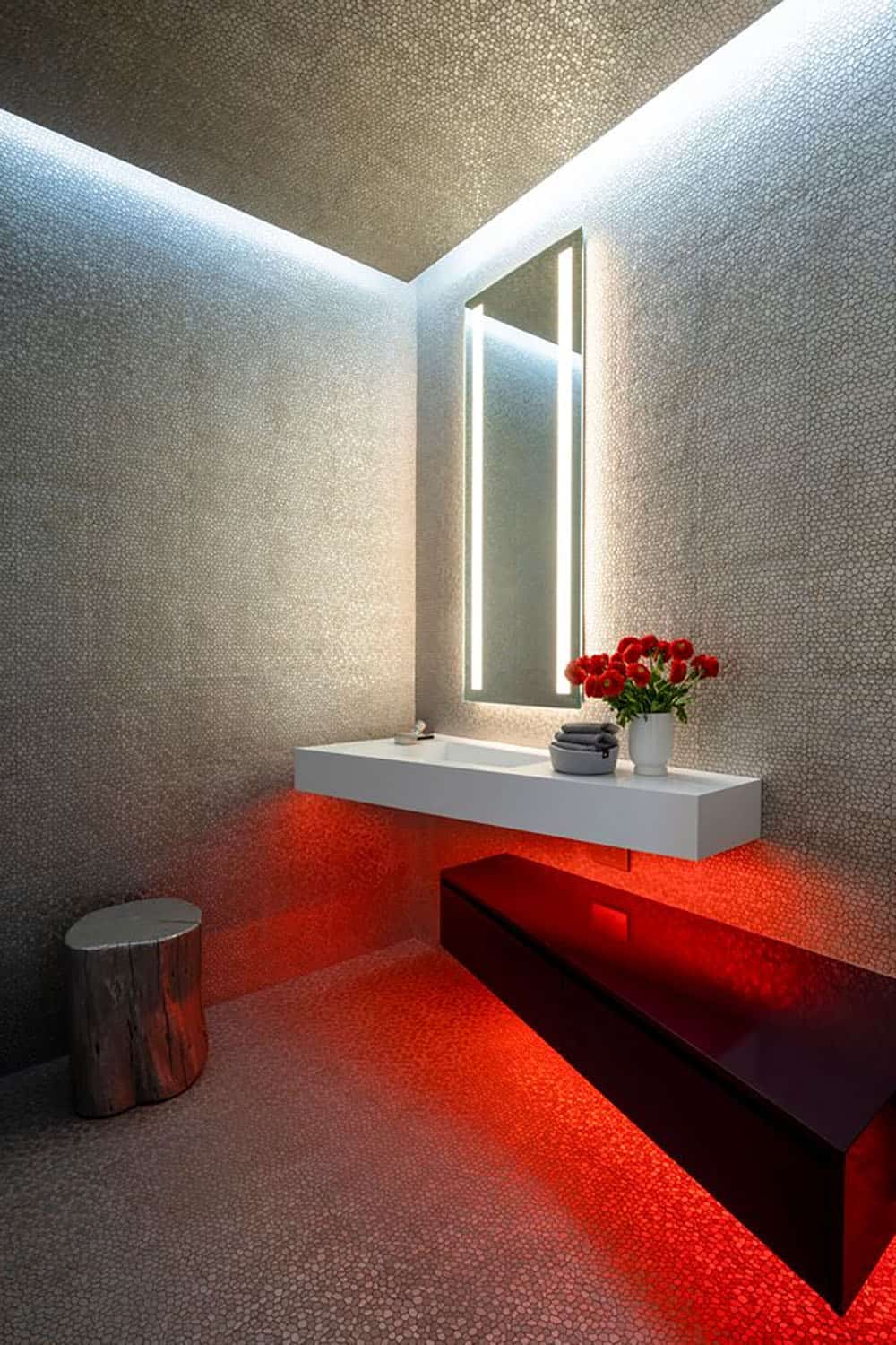A bathroom with red lighting and a sink.