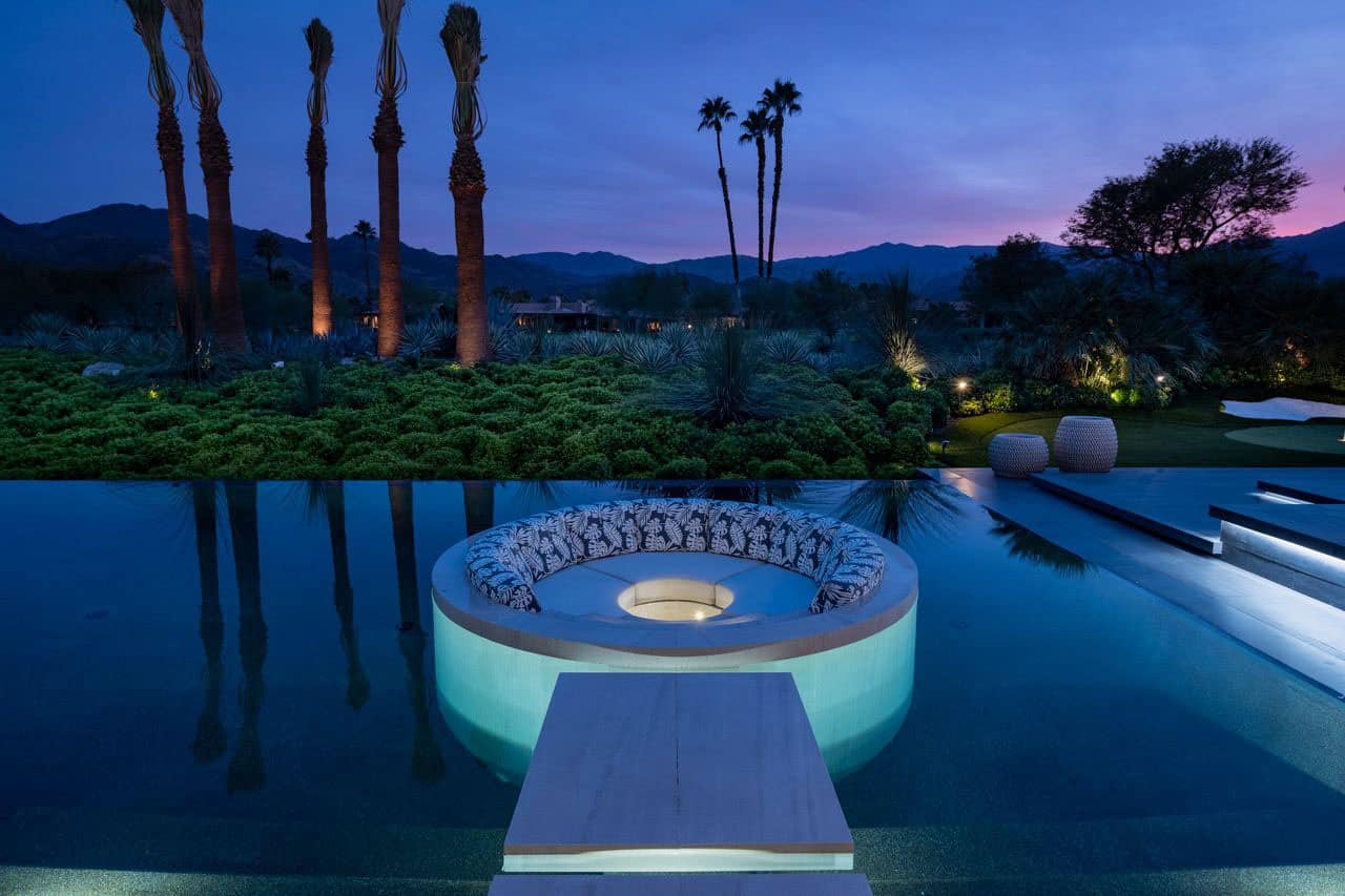 modern luxury house exterior with circular seting and a fire pit
