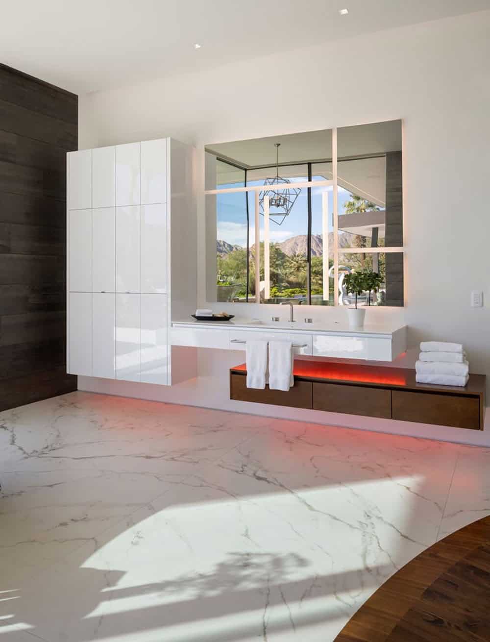 A modern bathroom with marble floors and white cabinets.