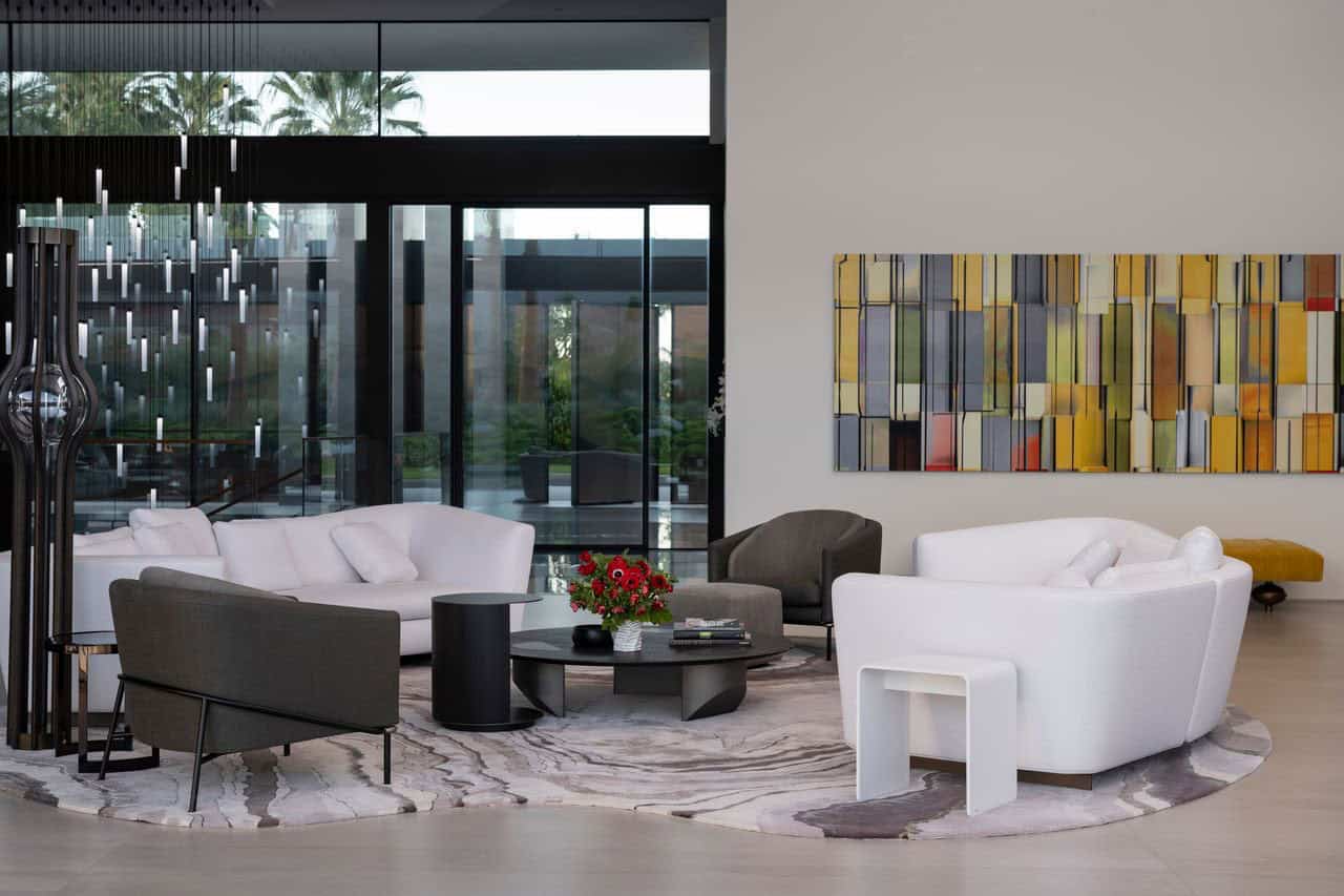 A modern living room with white furniture and art.