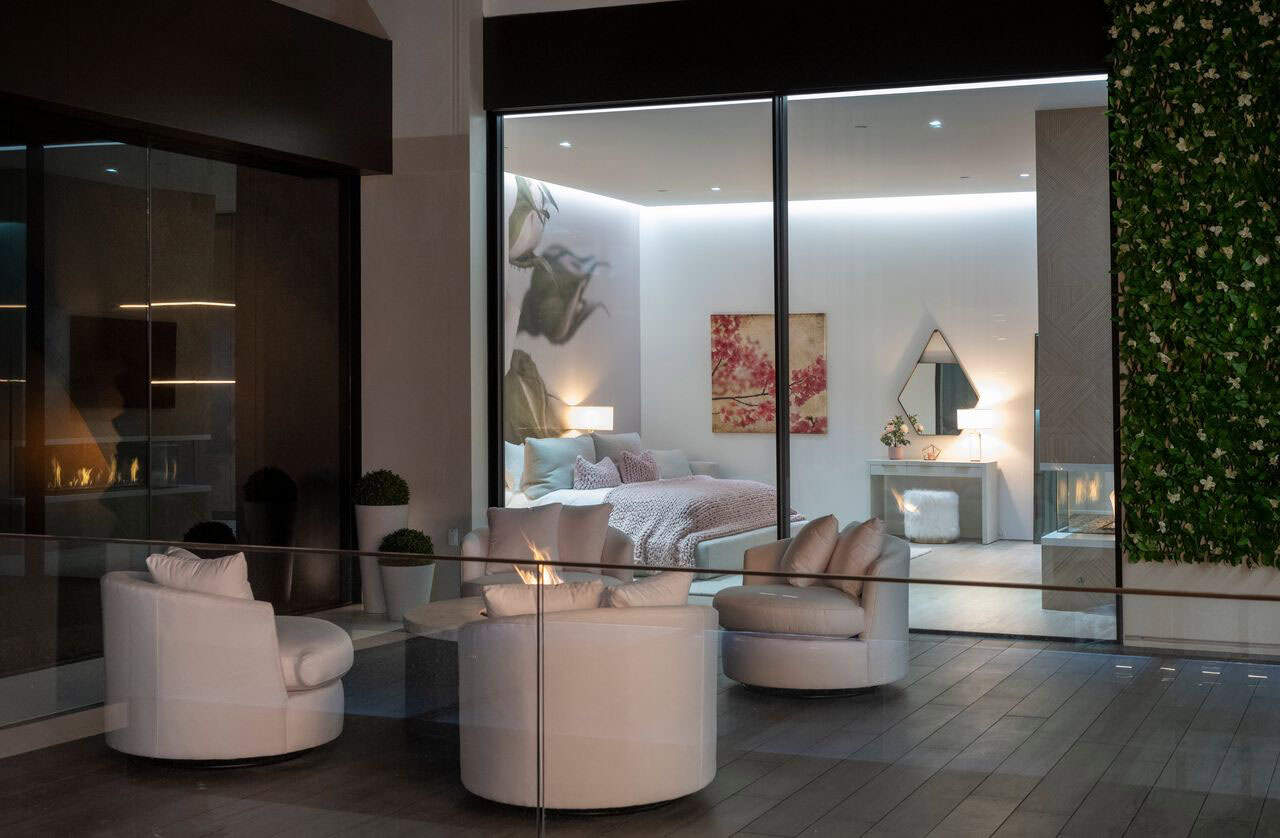 A modern living room with a fireplace and glass walls.