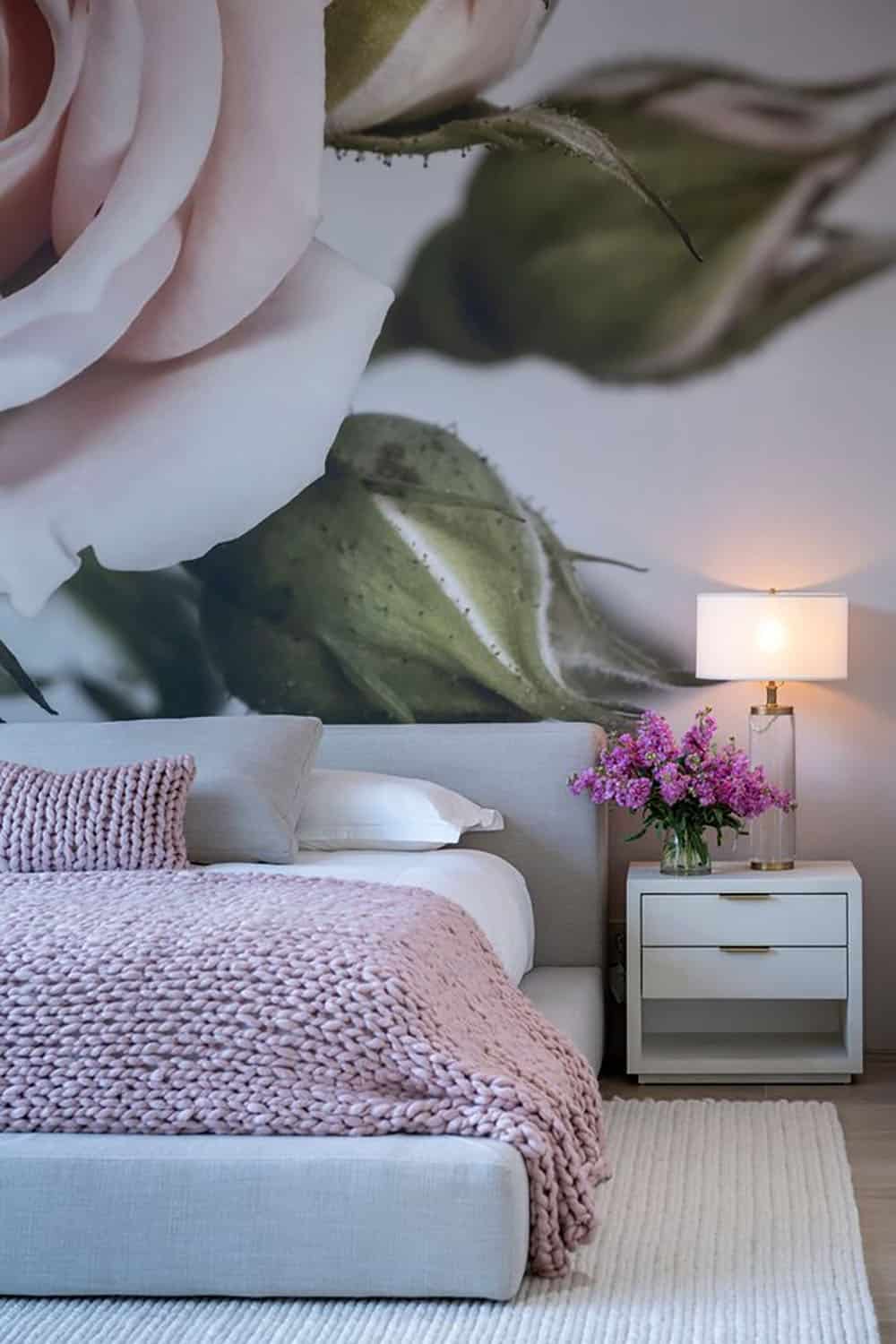 A bedroom with a large rose wall mural.
