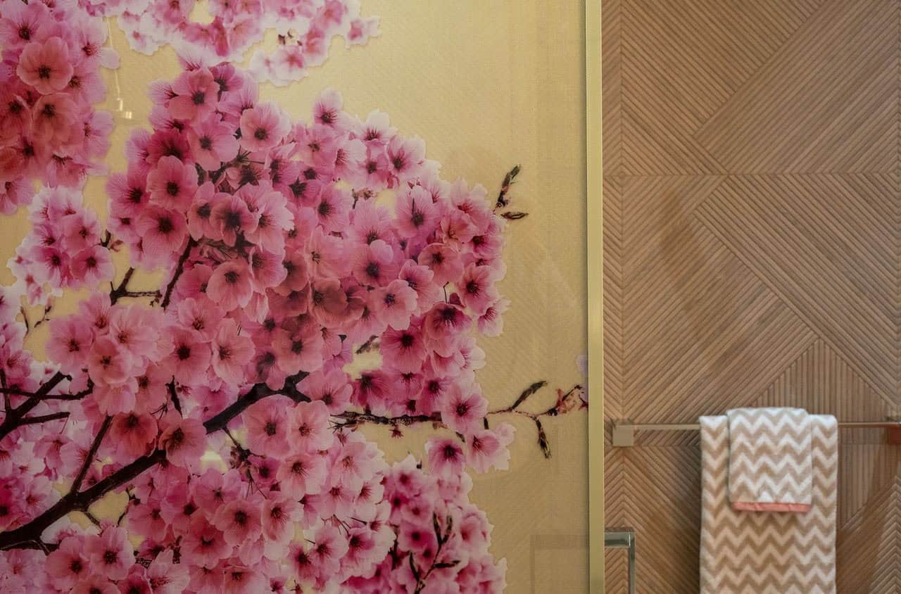 A bathroom with a pink flower painted on the wall.